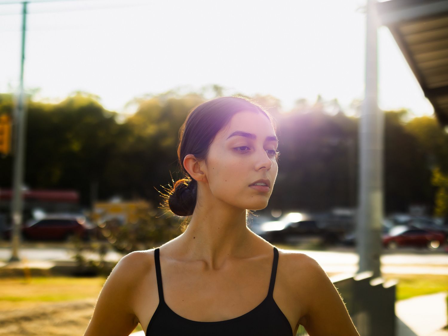 Athletic silhouette stretches against sunset sky in urban setting.