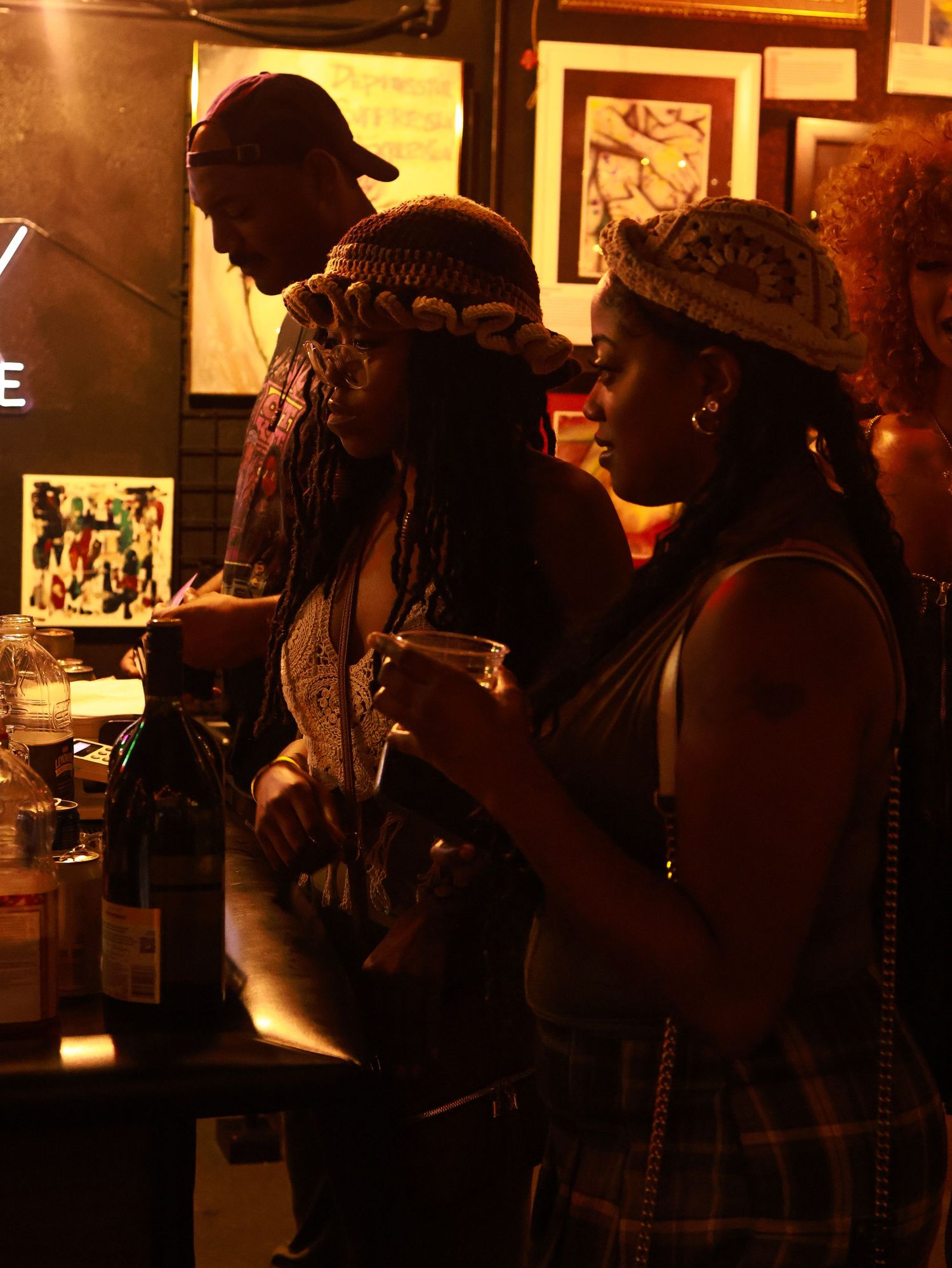 Silhouettes of people gathered in a venue with vintage photos and warm ambient lighting.