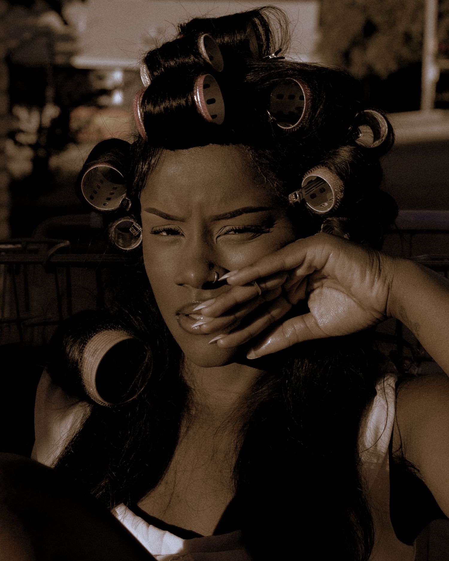 Sepia portrait series capturing candid expressions and hair styling moments.