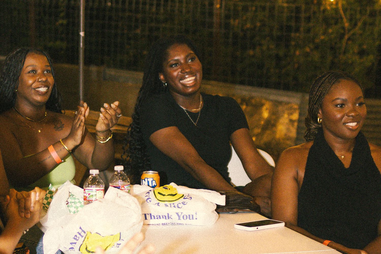 Friends sharing laughs and enjoying themselves at an outdoor table gathering.