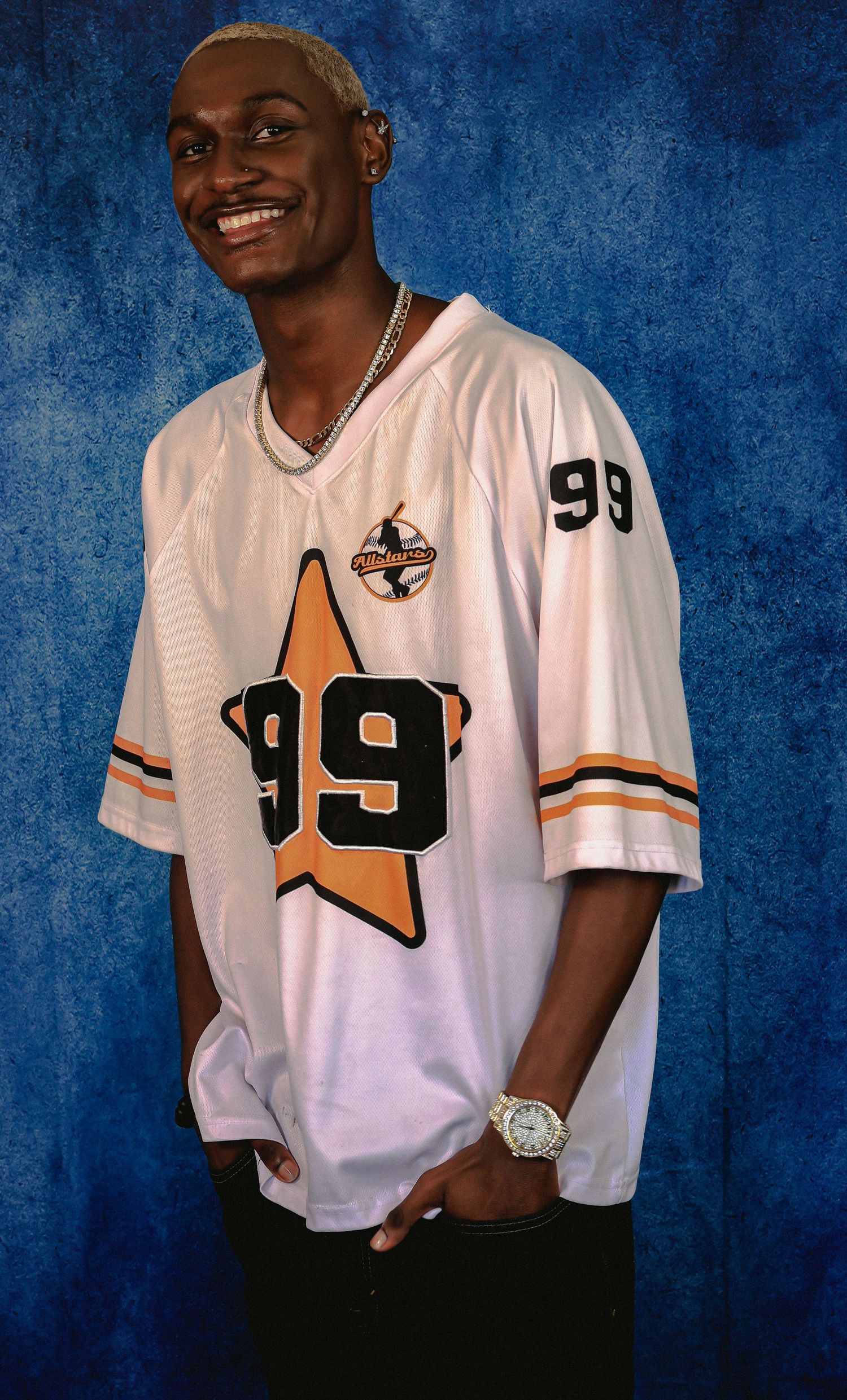 Person wearing white sports jersey with number 99 poses against blue background.