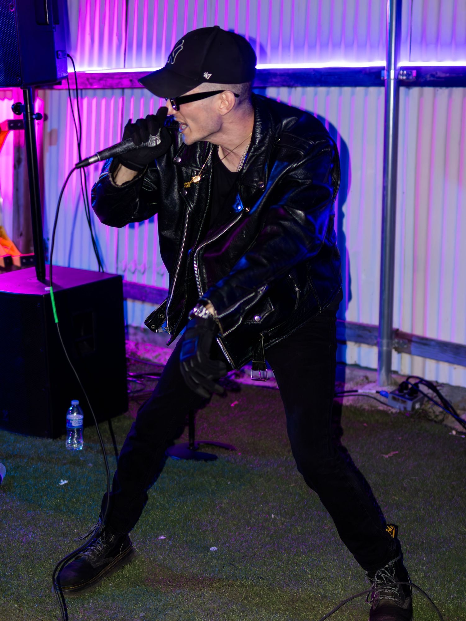 Energetic performer in dark clothing moves dynamically during nighttime show.