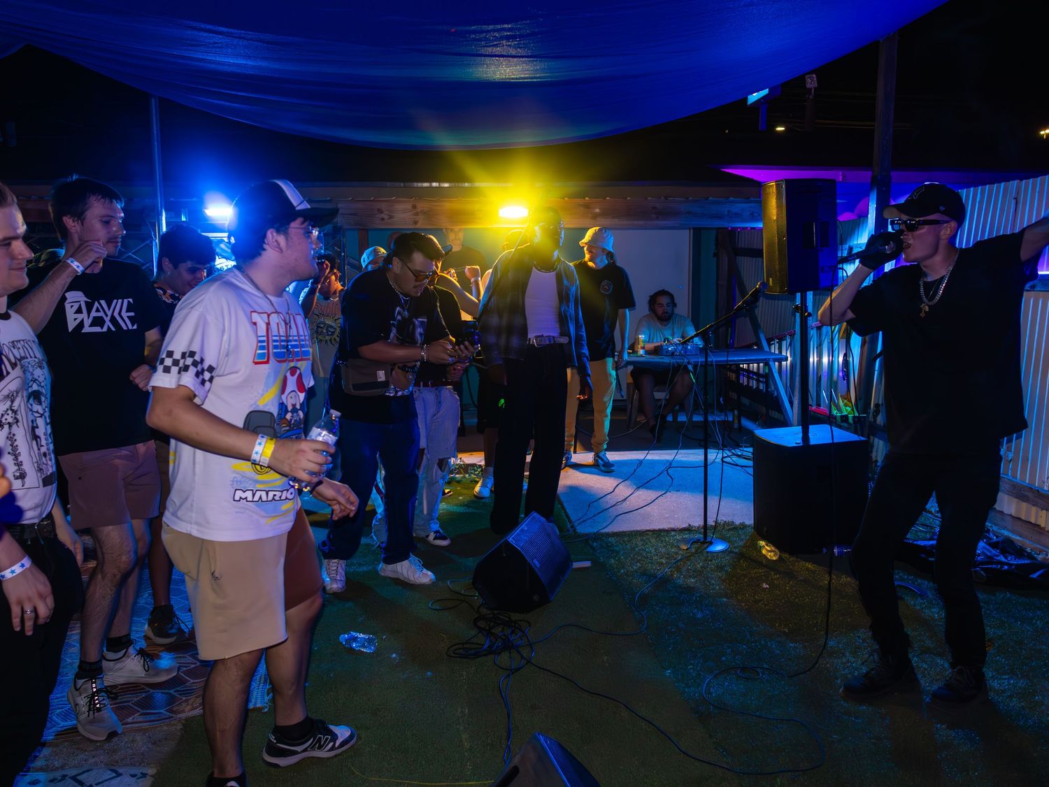 Nighttime concert scene with mixed blue and yellow lighting illuminating the crowd.