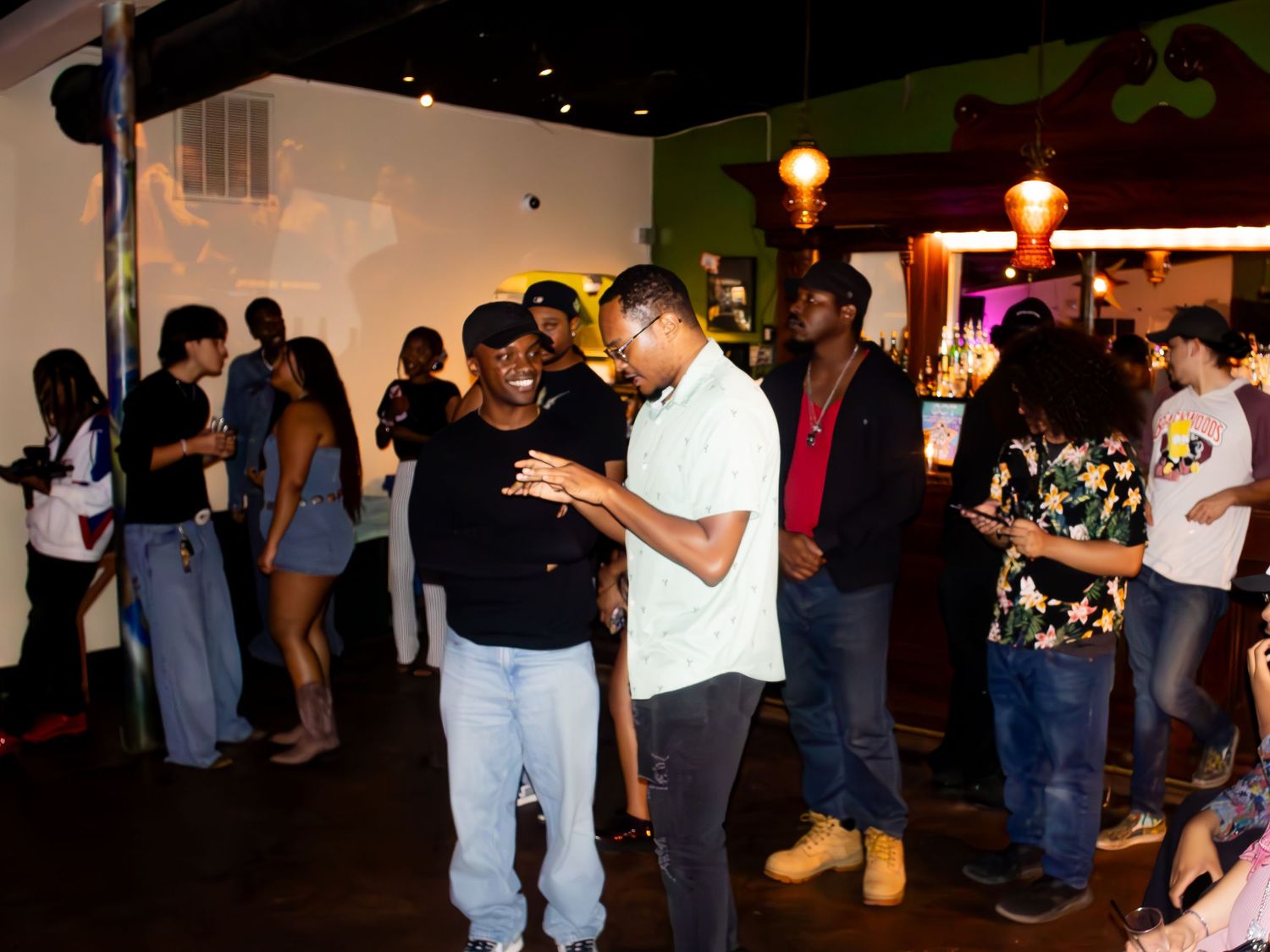 Crowded party scene with people mingling in casual attire.