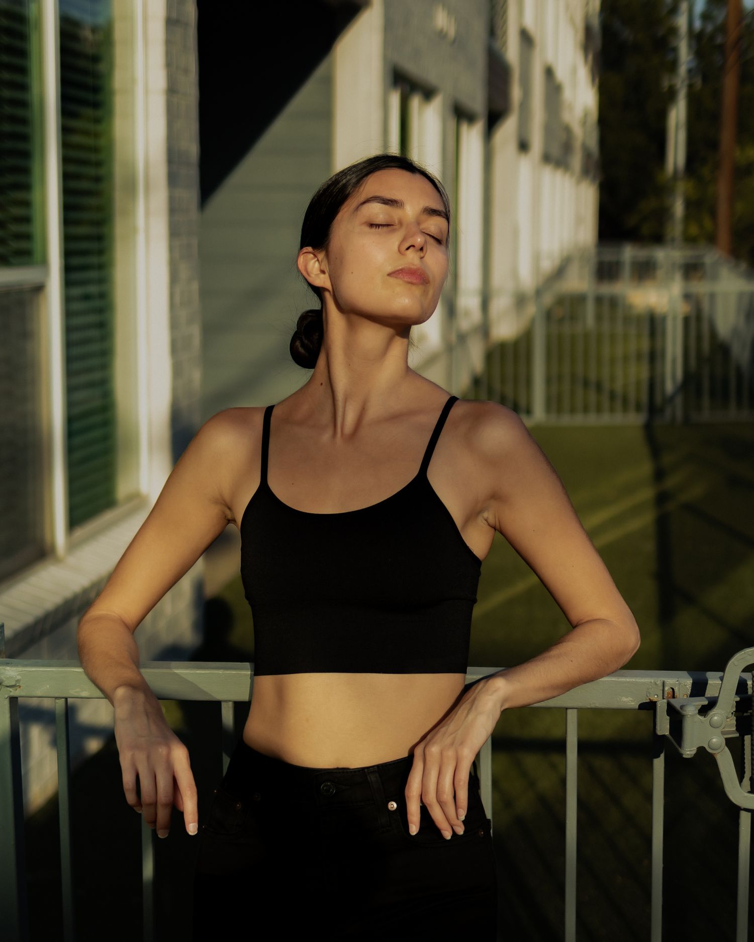 Athletic silhouette performs stretching poses against urban architecture in dramatic lighting.
