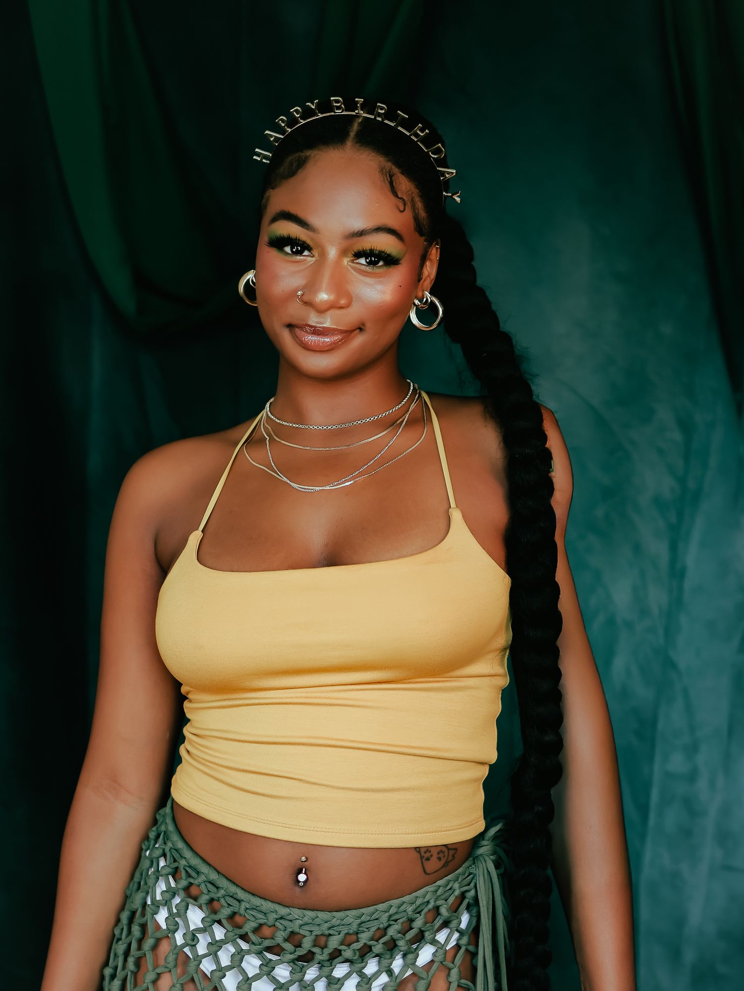 Fashion photo with yellow tank top and metallic skirt in moody lighting.