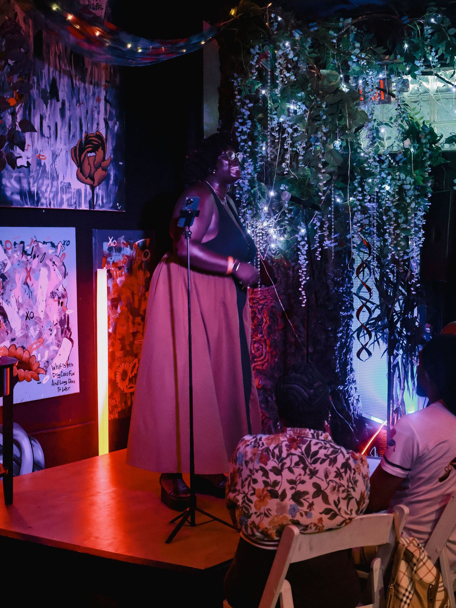 Event space setup with red floor lighting and hanging botanical decorations creating an immersive atmosphere.