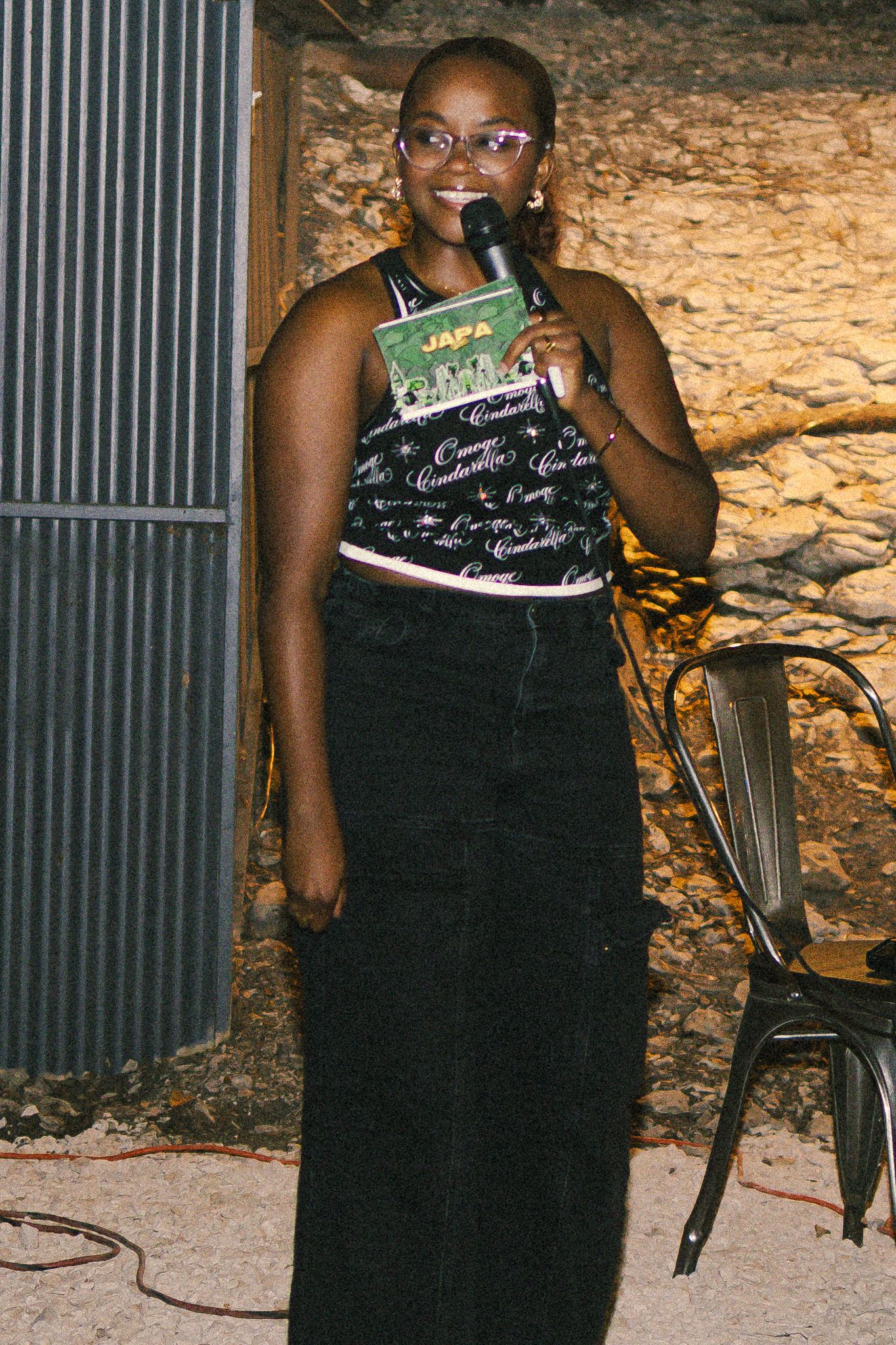 Person wearing a patterned top and glasses at an outdoor event.