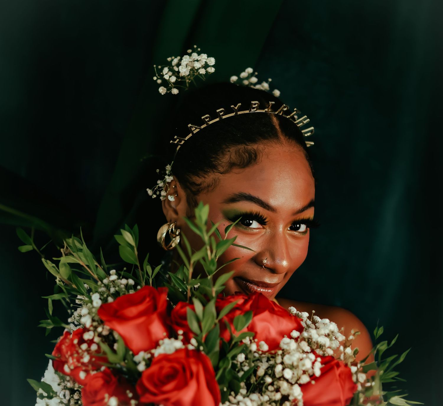A series of artistic portraits showing someone wearing red roses and baby's breath flowers in their hair against a dark background.