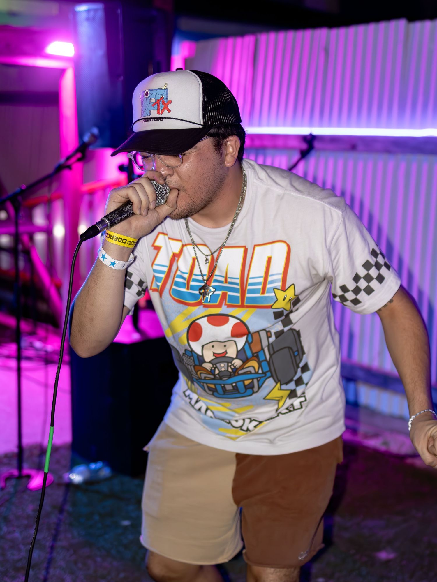 Energetic performance on stage with Nintendo-themed attire and dramatic purple lighting.