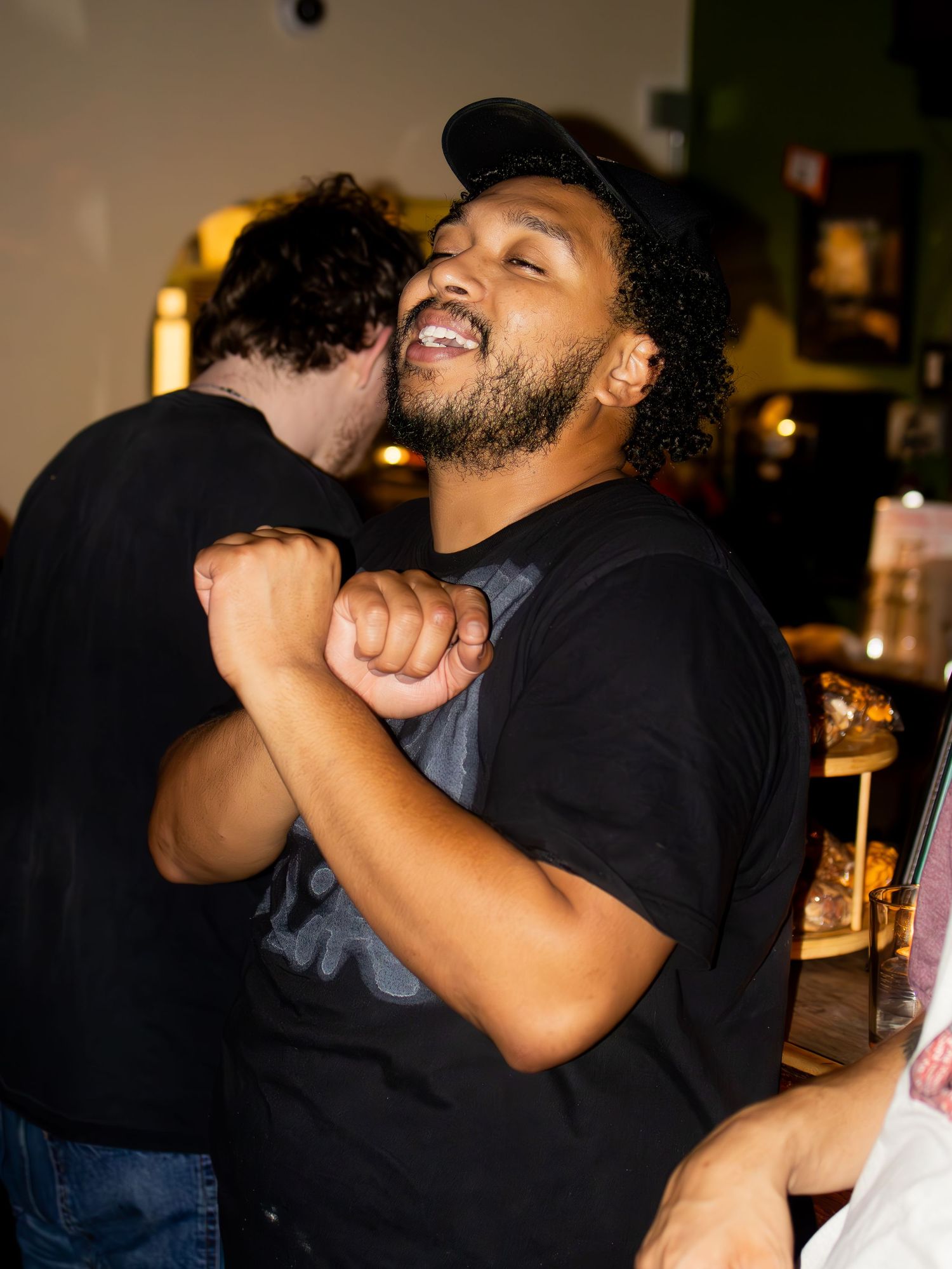 People embracing in a dimly lit indoor setting.