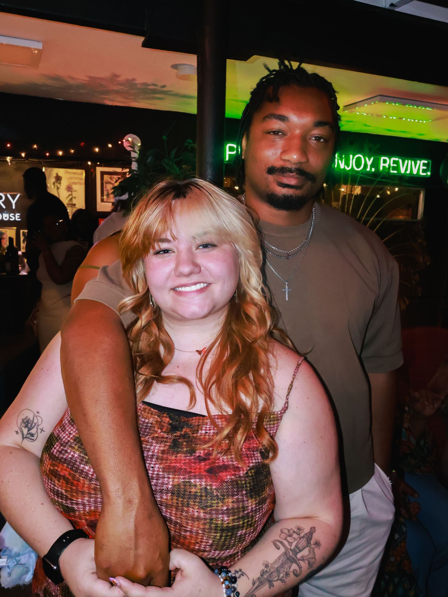 A casual nighttime gathering with people posing together in an outdoor setting.