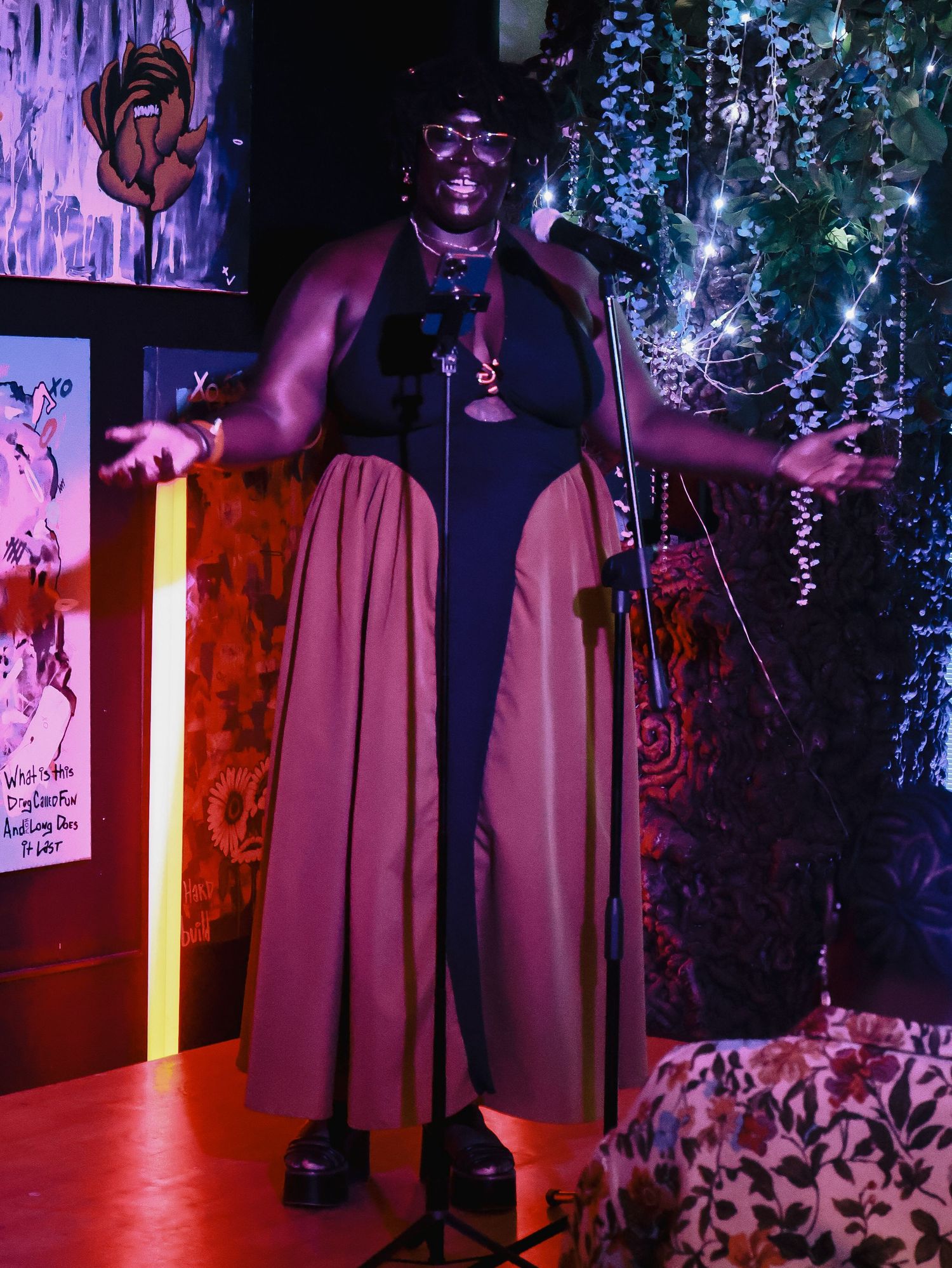 Dramatic purple and red lighting illuminates a stage setup with hanging decorative elements.