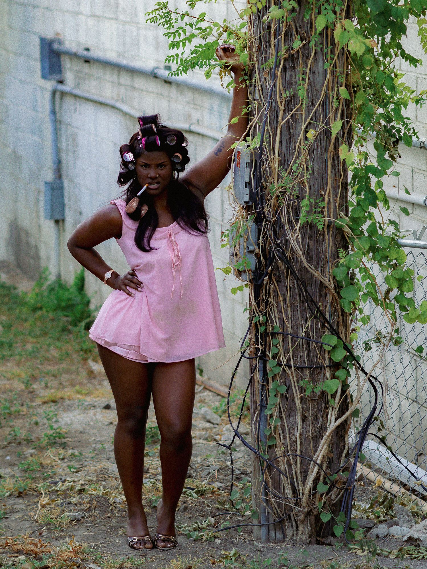Expressive dance movements photographed in outdoor setting with climbing plants.
