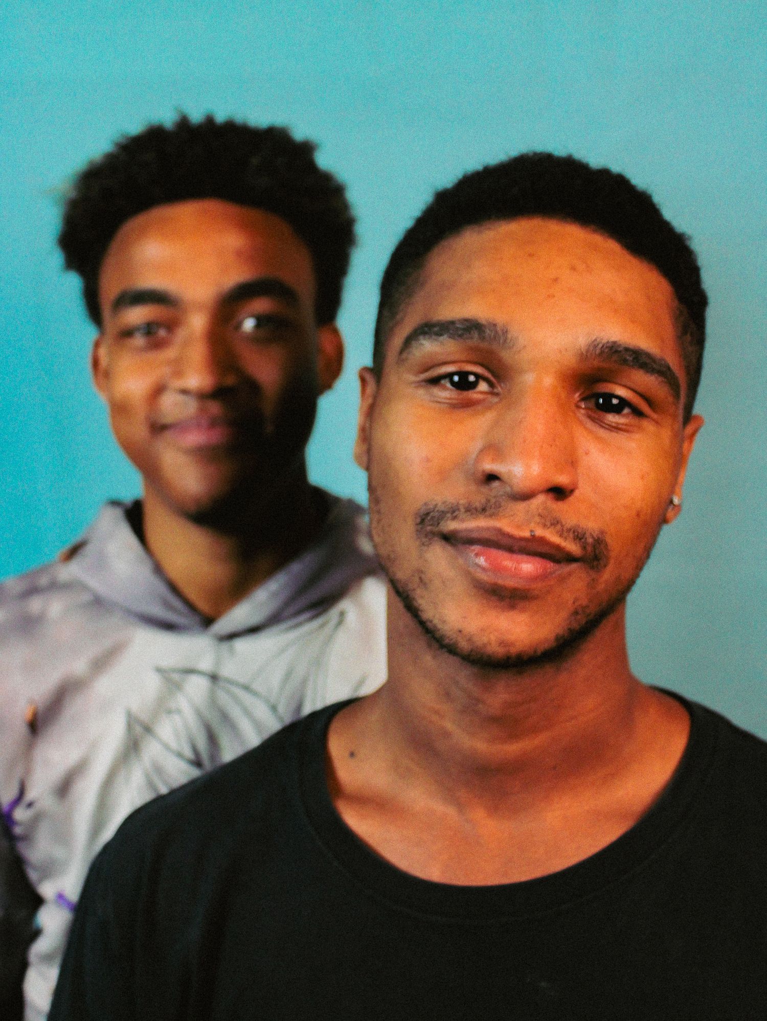 Candid portrait sequence against turquoise background showing bright smiles.