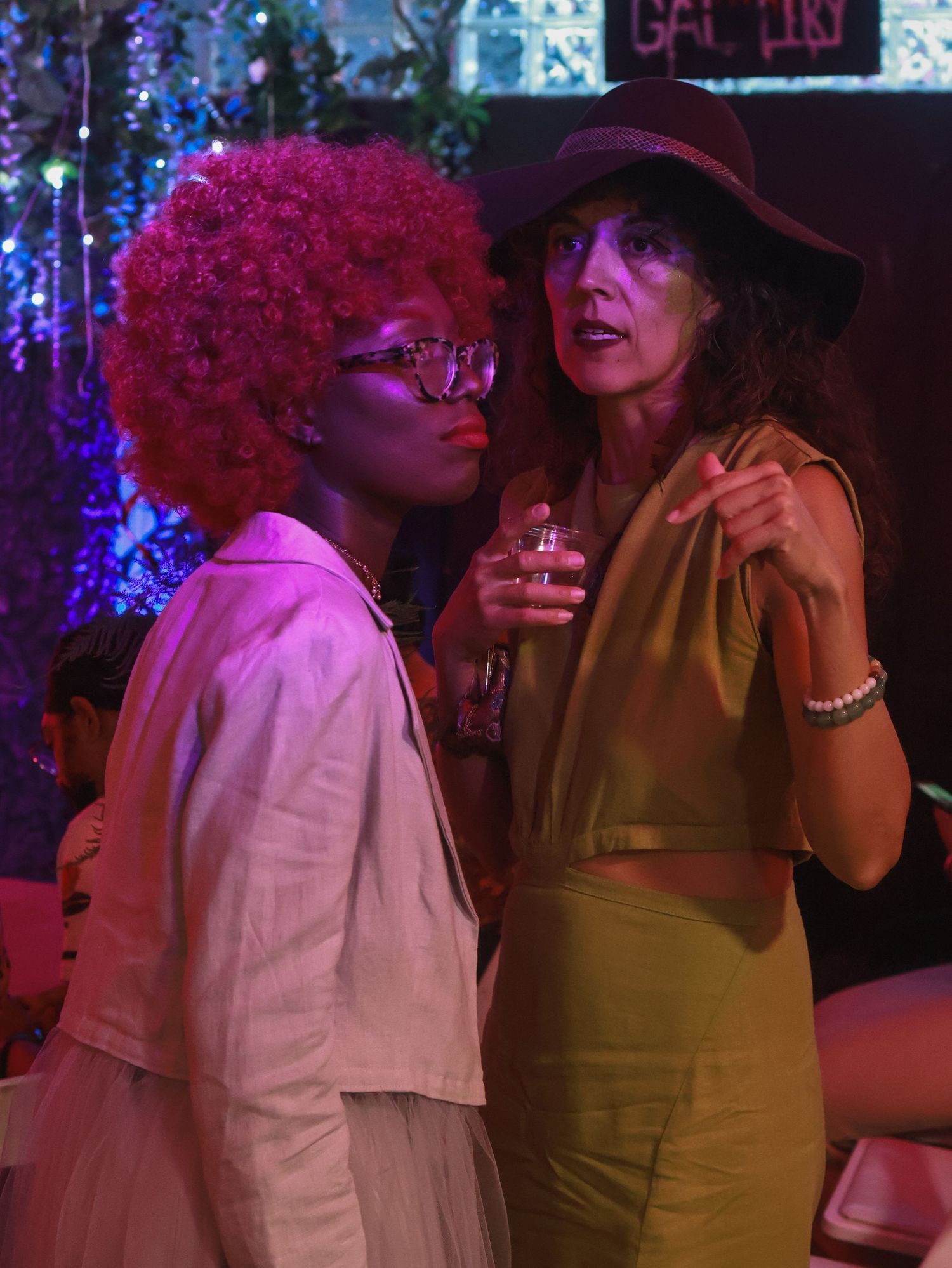 Nightclub scene bathed in blue and purple lighting with people enjoying the atmosphere.