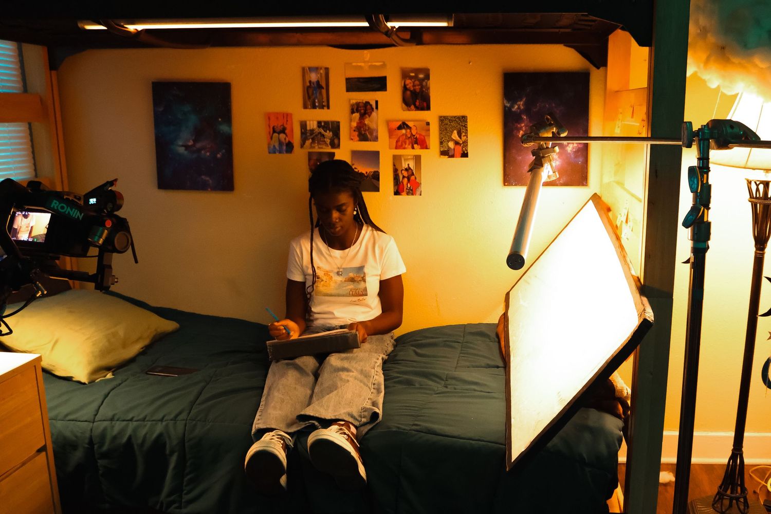 Behind-the-scenes film production setup with warm lighting and equipment in a small room.
