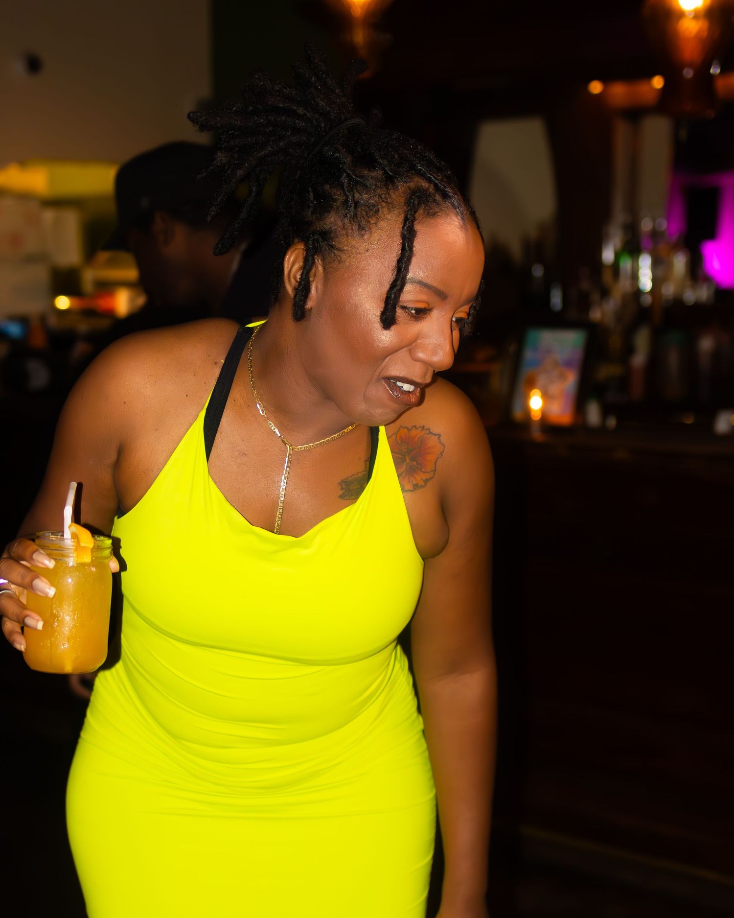 Person wearing bright neon yellow top in a dark indoor setting.