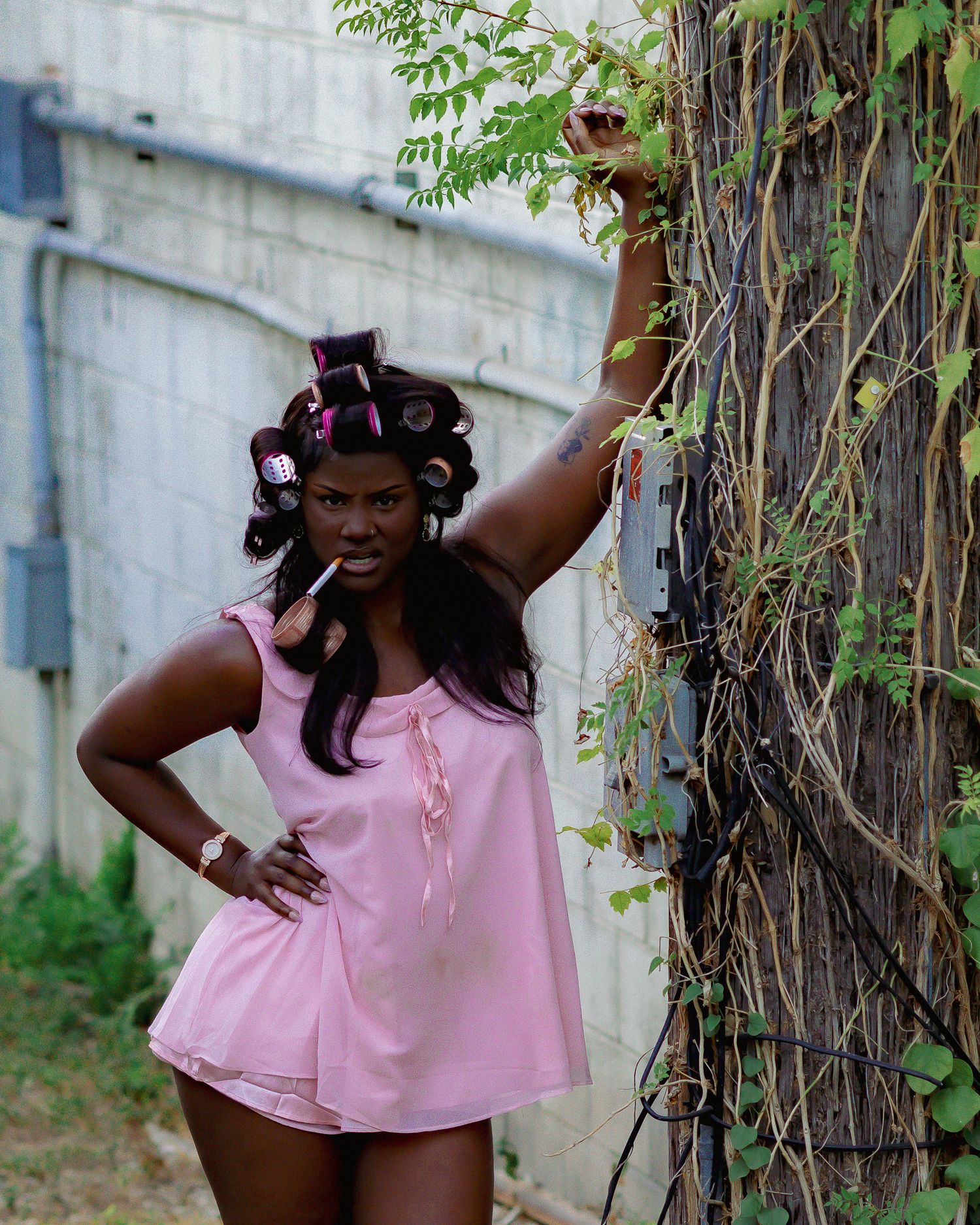 Dynamic poses captured against concrete wall and climbing vines wearing pink.