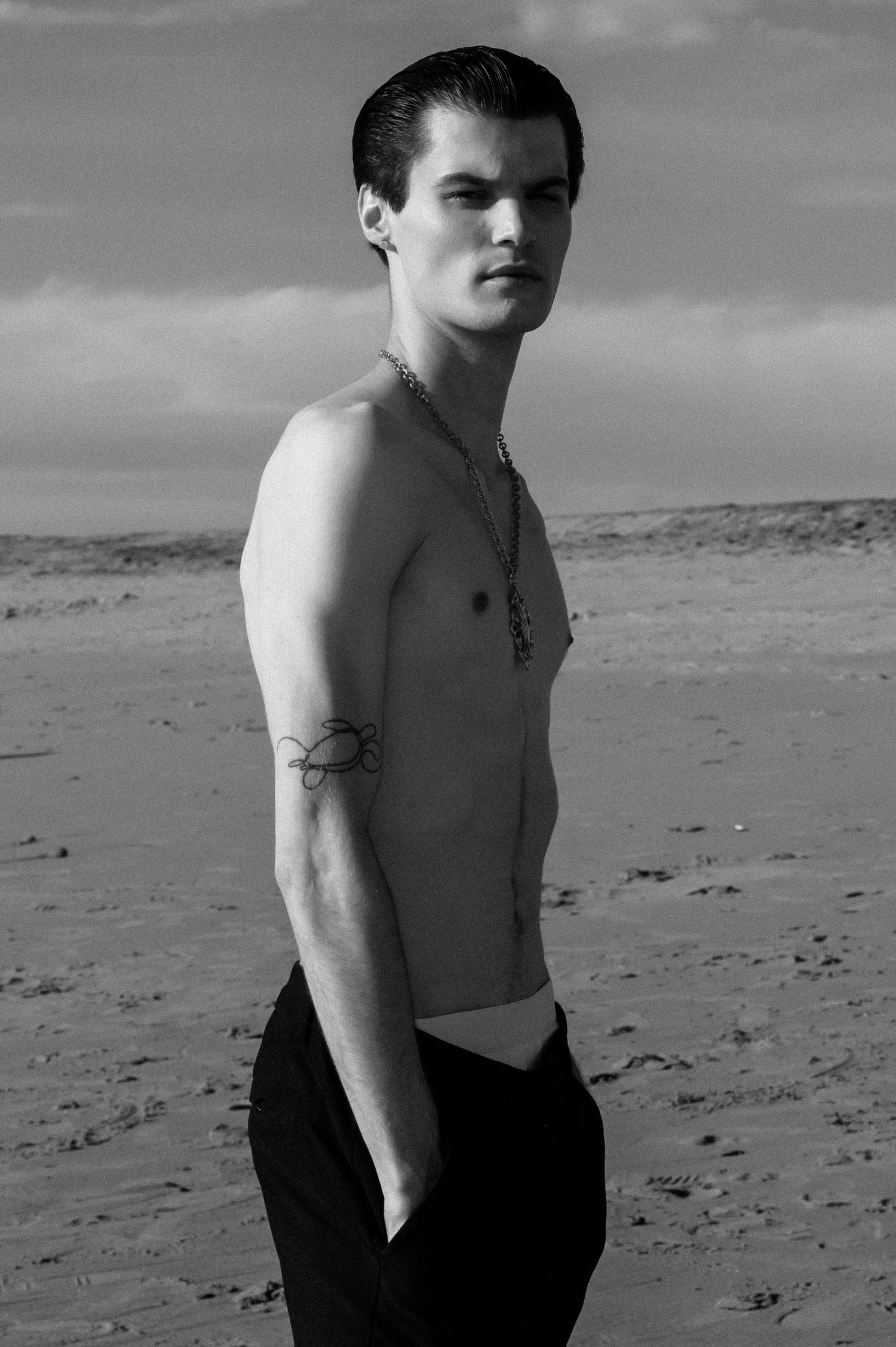 Black and white beach portrait showing dramatic shadows and desert landscape.