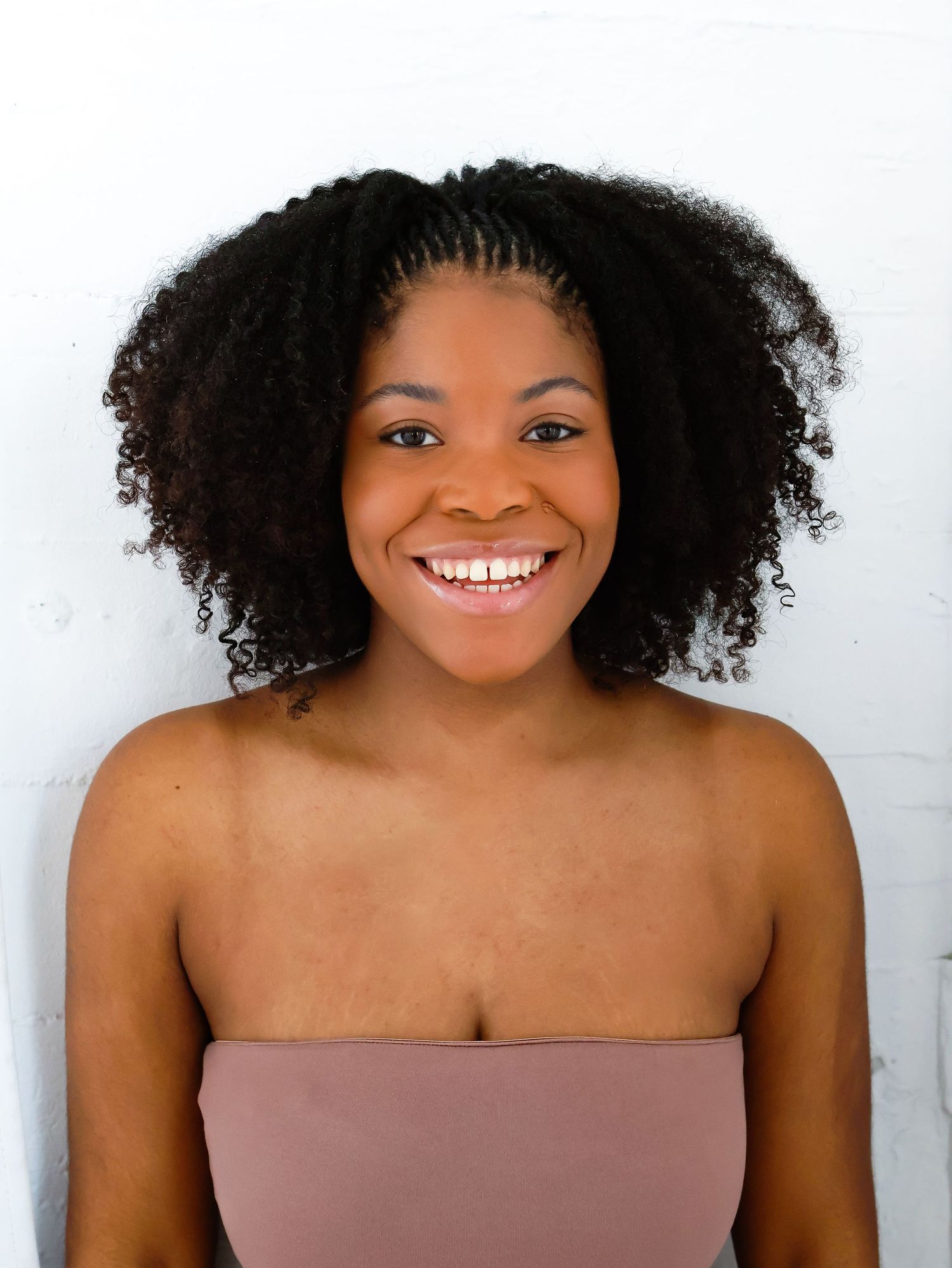 Studio portraits featuring natural curls and genuine smiles against white backdrop.