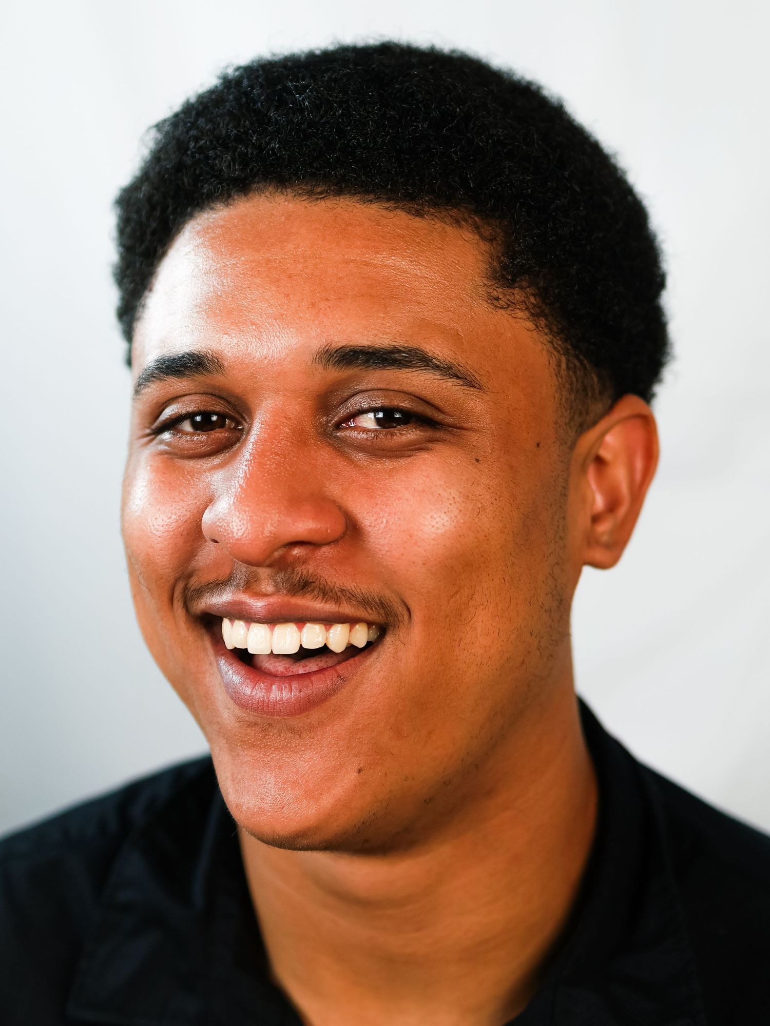 A sequence of joyful laughing expressions captured in a black and white portrait series.