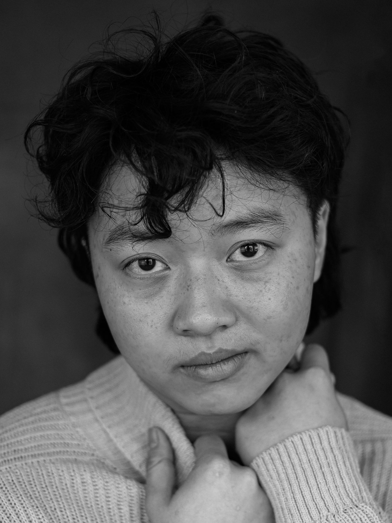 Intimate black and white portrait in soft sweater showing contemplative expression.