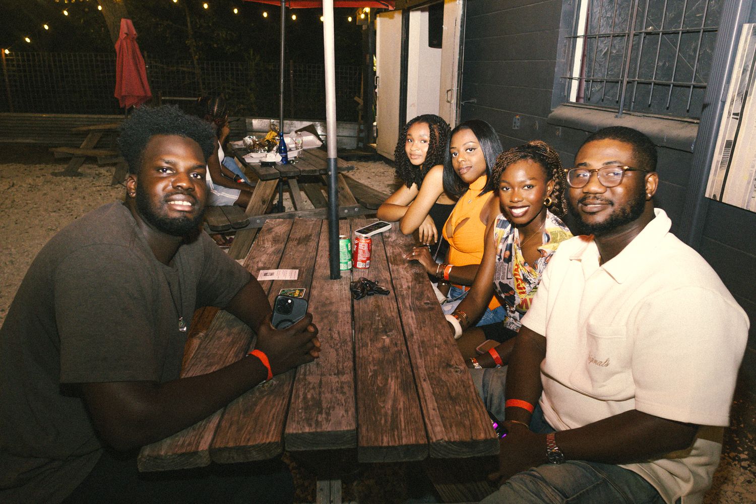 Groups of people seated at tables enjoying an evening gathering under ambient lighting.