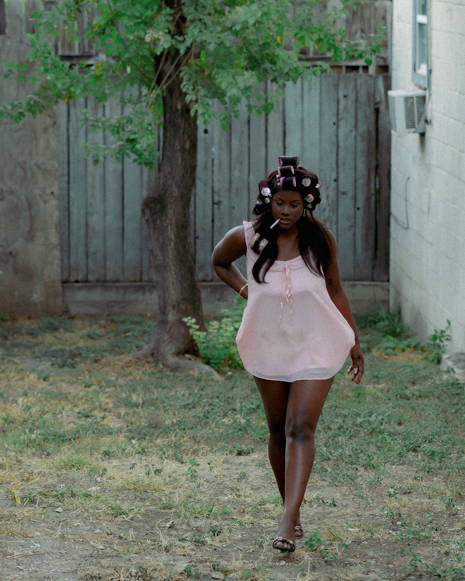 Outdoor portrait series showing movement and poses against an urban garden backdrop.