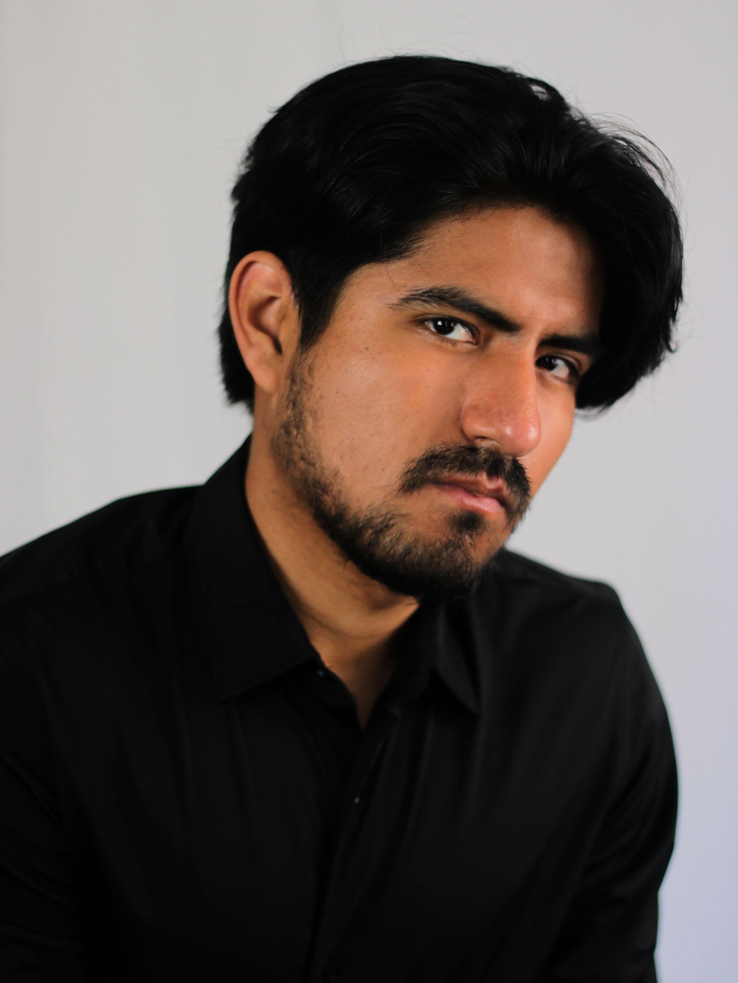 Moody portrait series in black attire against light gray background.