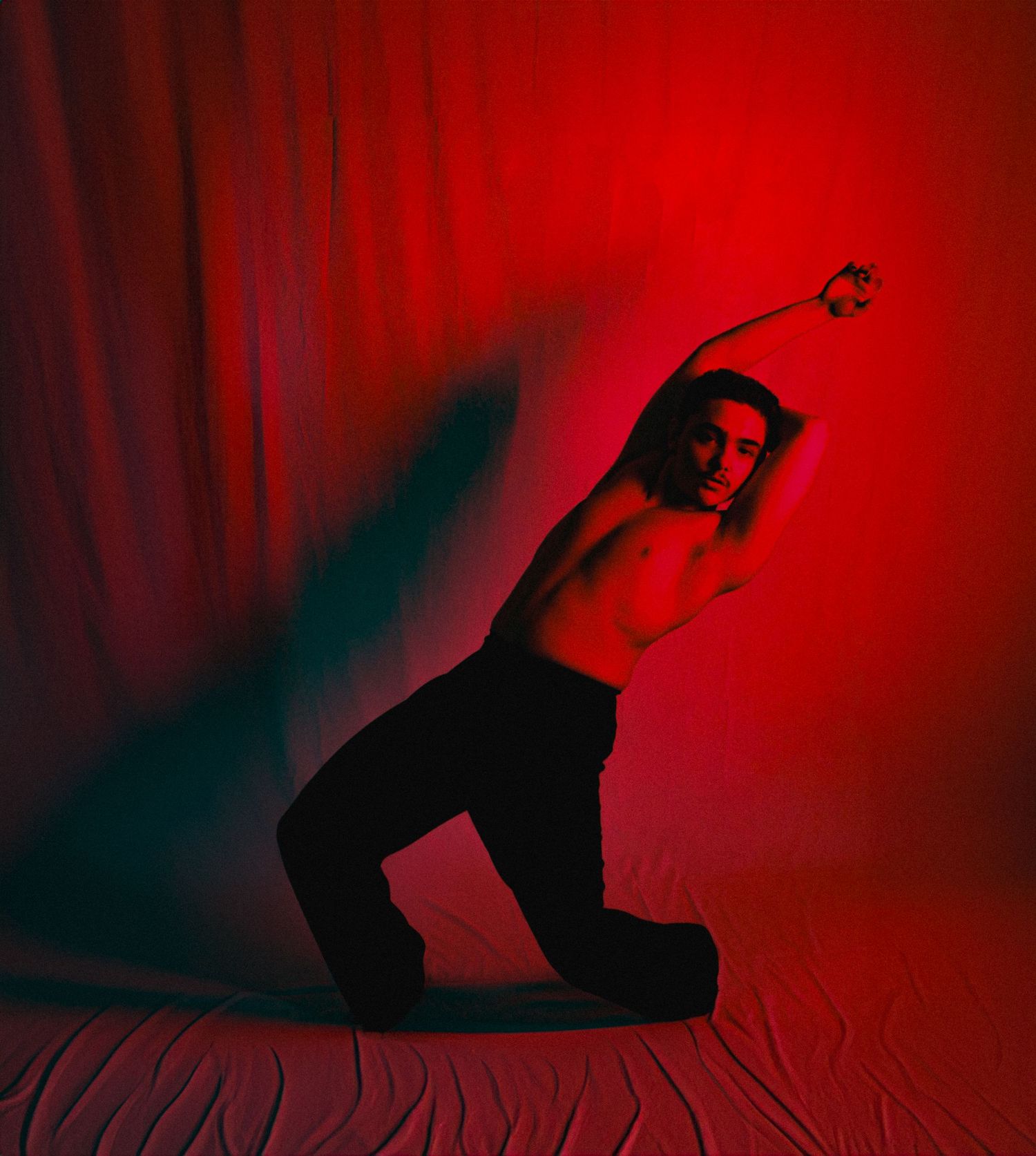 Dynamic dance poses silhouetted against vibrant red backdrop with dramatic shadows.