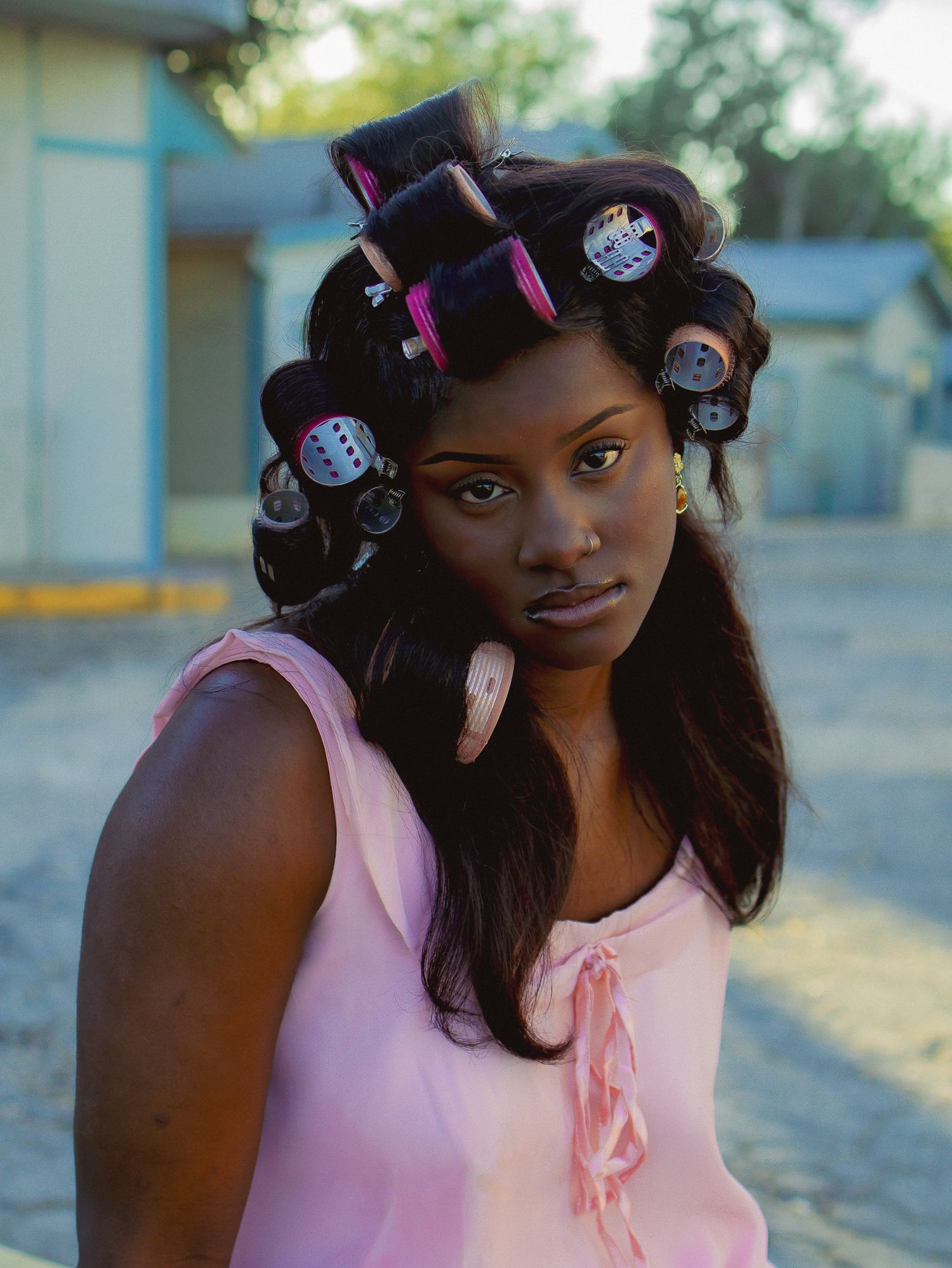Close-up fashion portrait showcasing pink clothing and vintage-inspired hair styling.