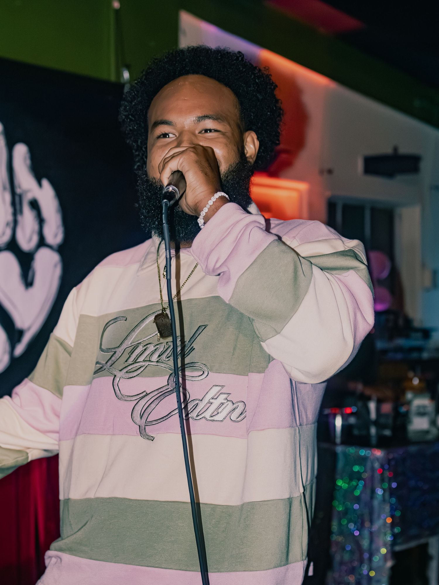 A dynamic performance shot with colorful stage lighting and urban streetwear styling.