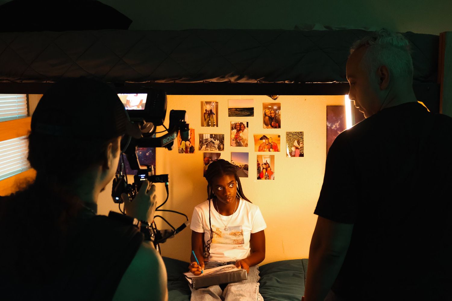 Dark atmospheric shot of video production crew working with equipment in indoor setting.