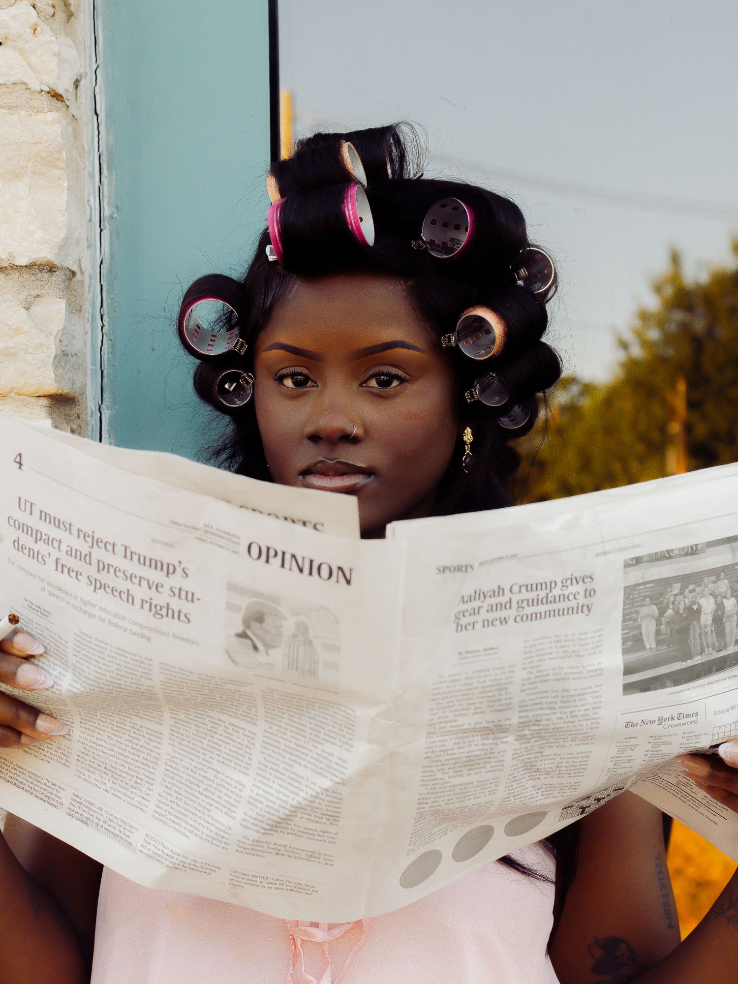 Candid moment of newspaper reading during outdoor photo session.