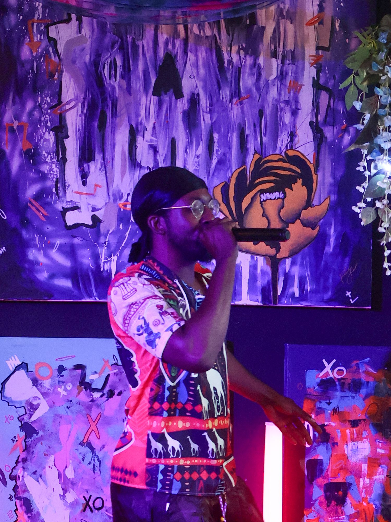 Purple-lit stage decorated with hanging elements and colorful backdrop during performance.