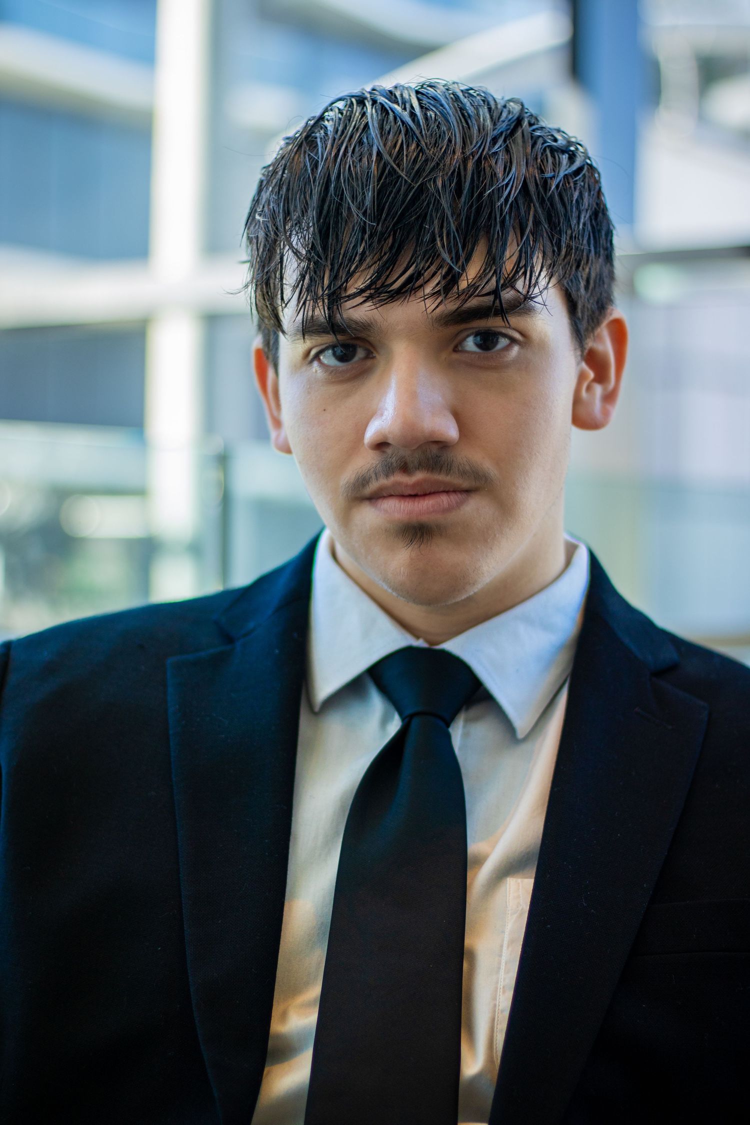 Close-up portrait of person in business attire against blurred background.