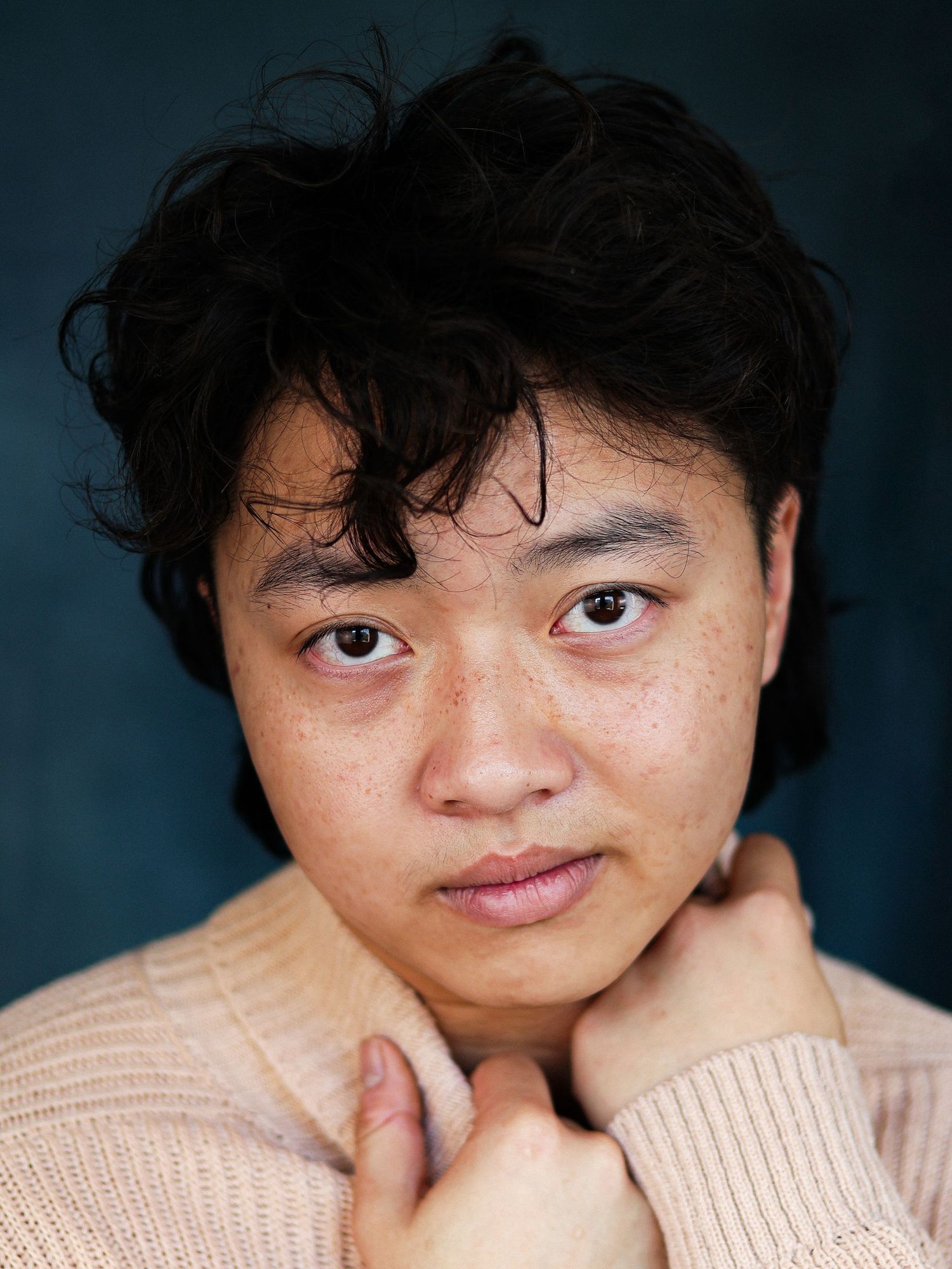 Close-up black and white portrait with gentle smile in cozy sweater.