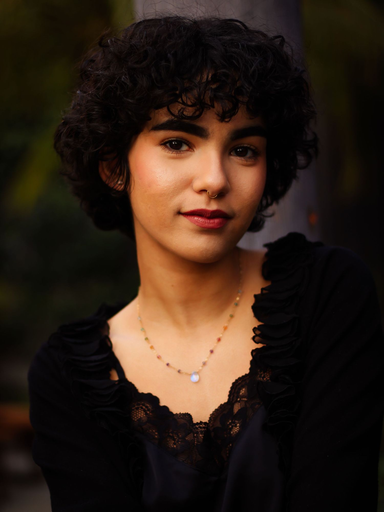 Dramatic portrait in black lace dress with dainty necklace.
