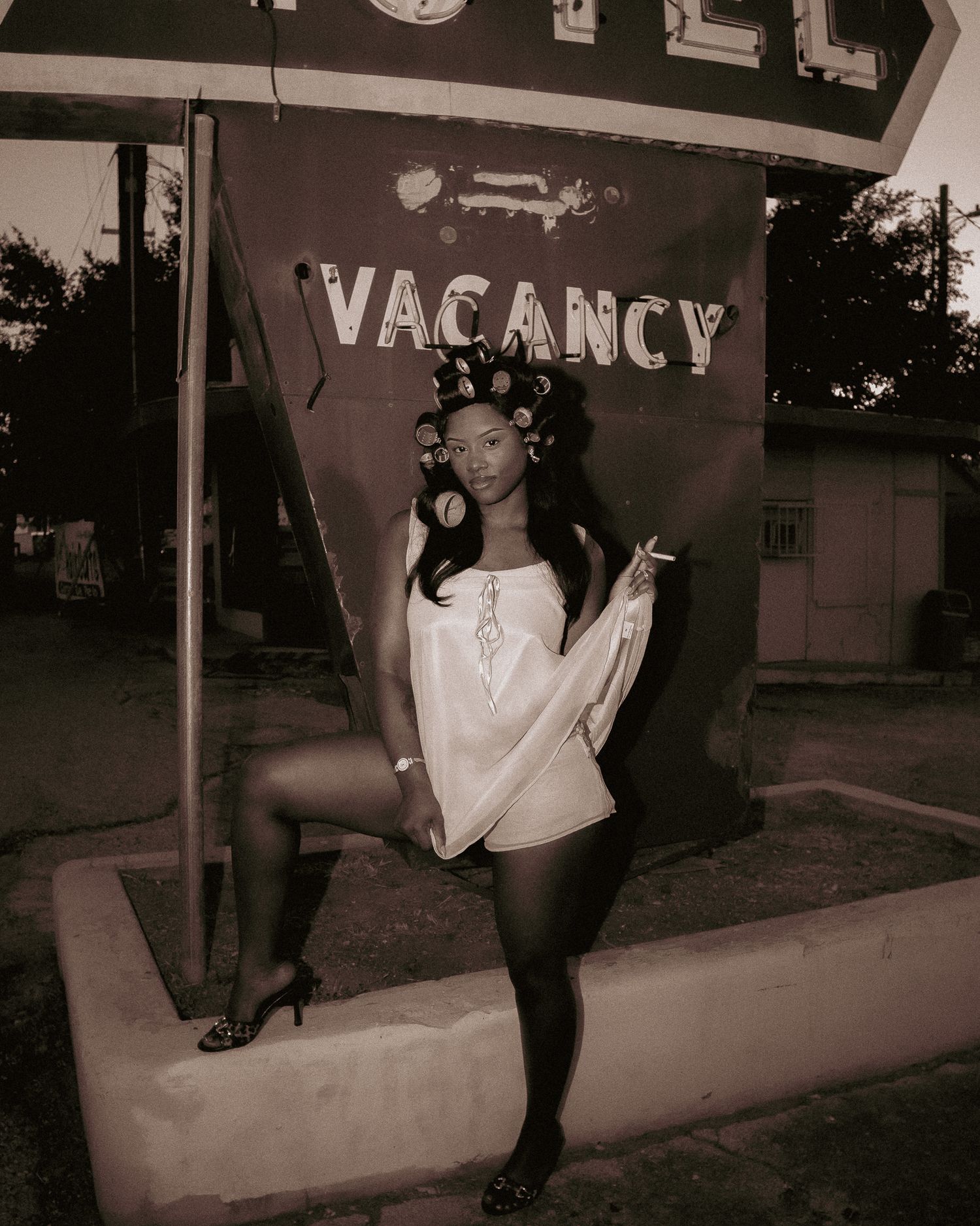 Sepia-toned motel photoshoot with vintage aesthetic and dramatic shadows.