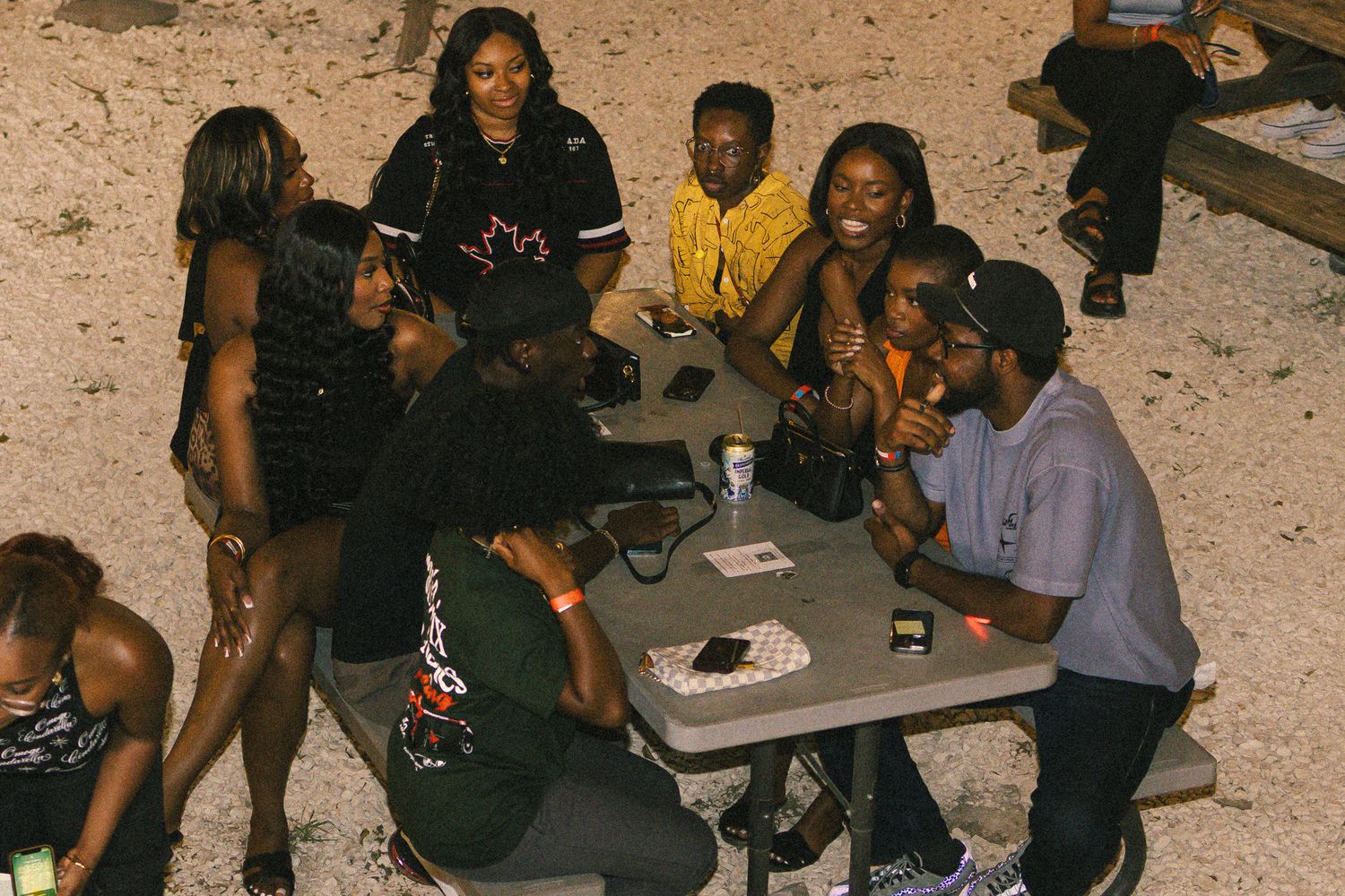 Group gathered around a table playing cards or games outdoors.