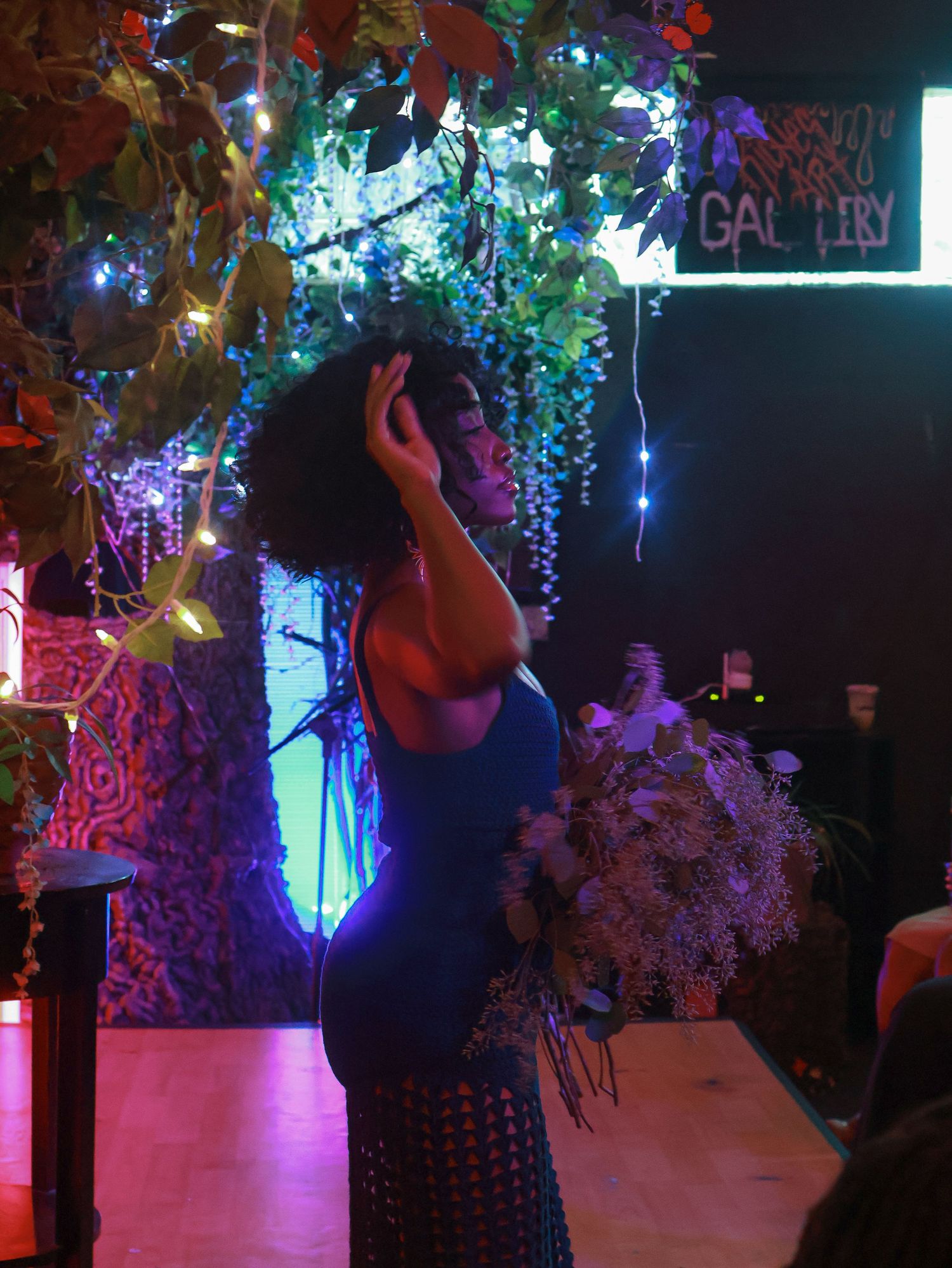 A performance venue decorated with colorful LED lights and hanging floral arrangements creates a magical ambiance.