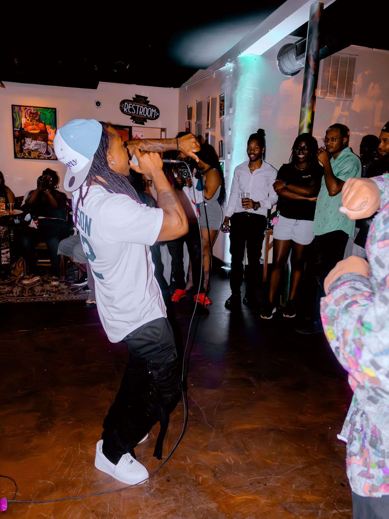 Dynamic performance shot showing artist on stage with crowd visible in background.