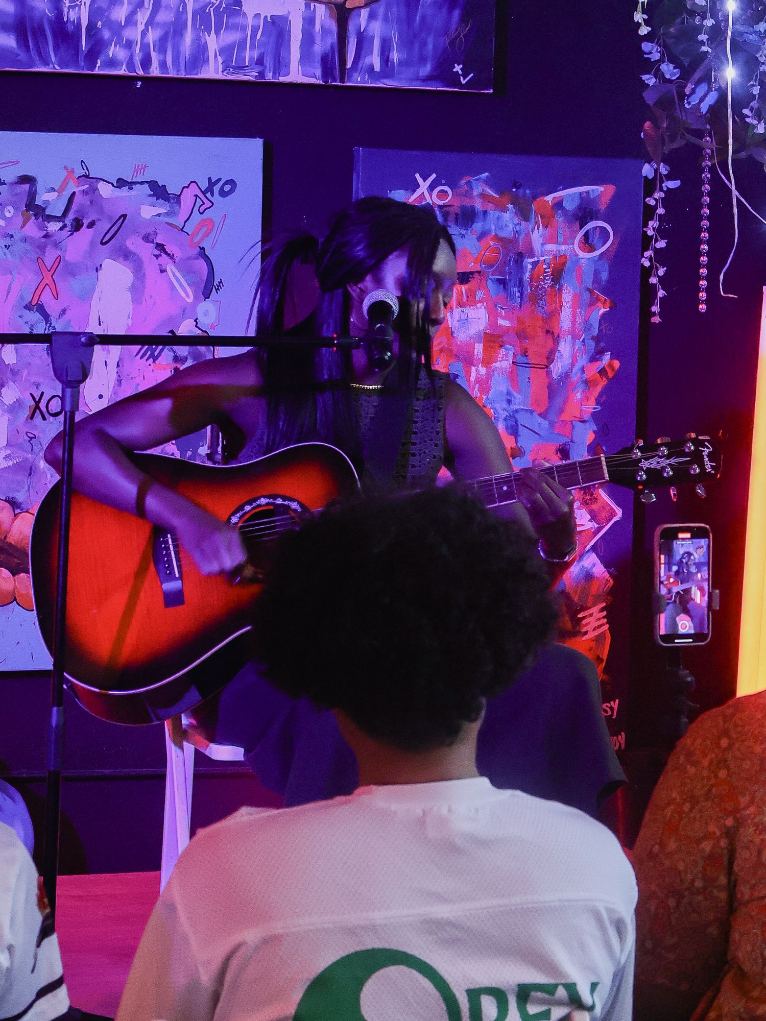 Concert venue with colorful lighting displays acoustic guitar setup and audience seating.