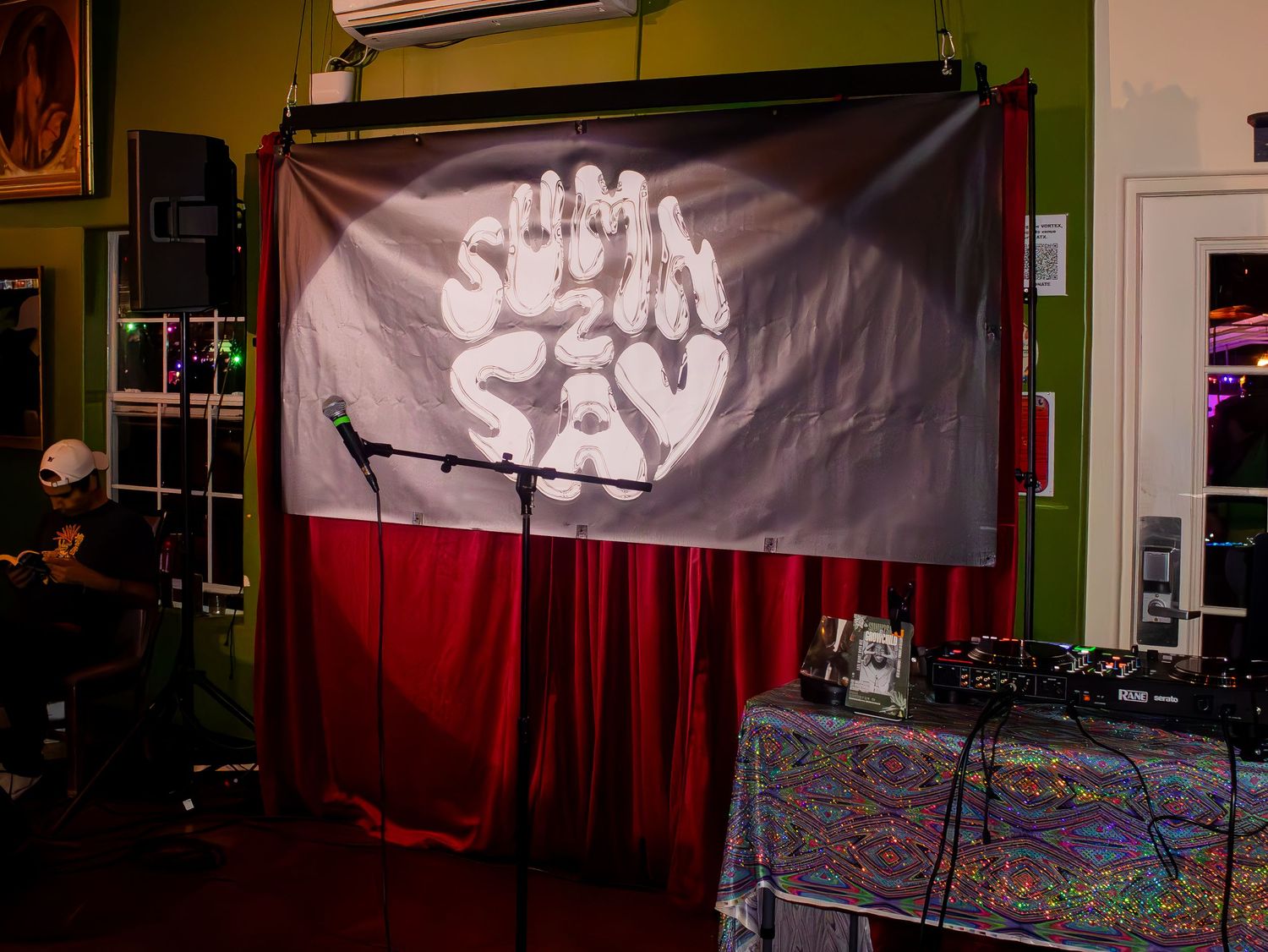 Dark indoor space with banners and decorative elements visible on the walls.