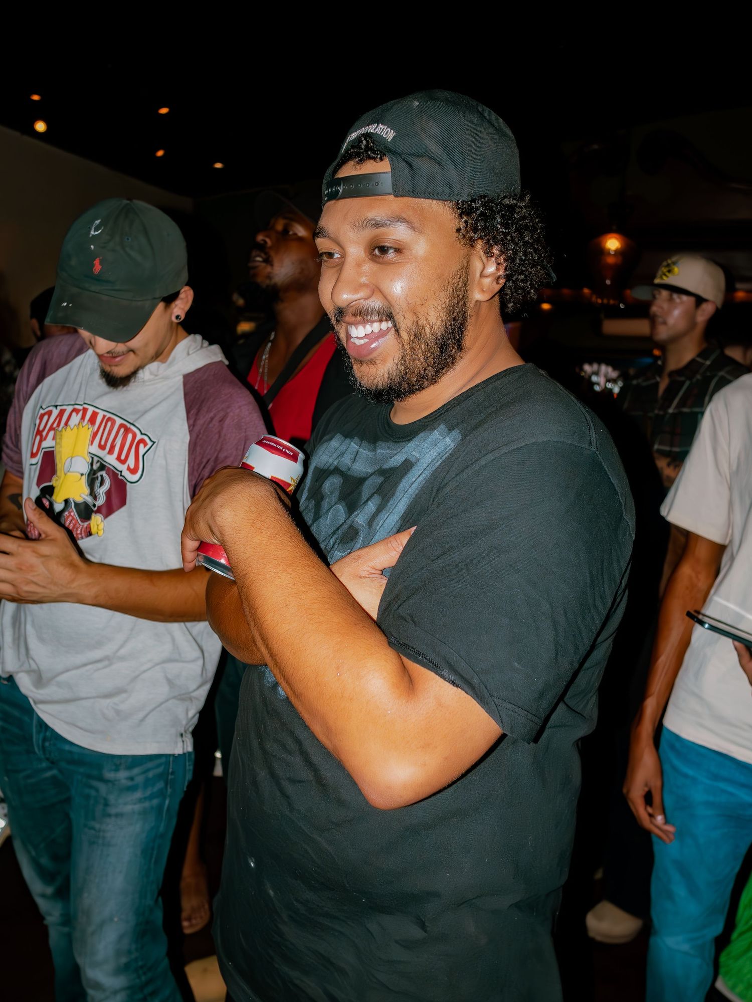 A group of people enjoying a lively nighttime gathering with drinks and laughter.