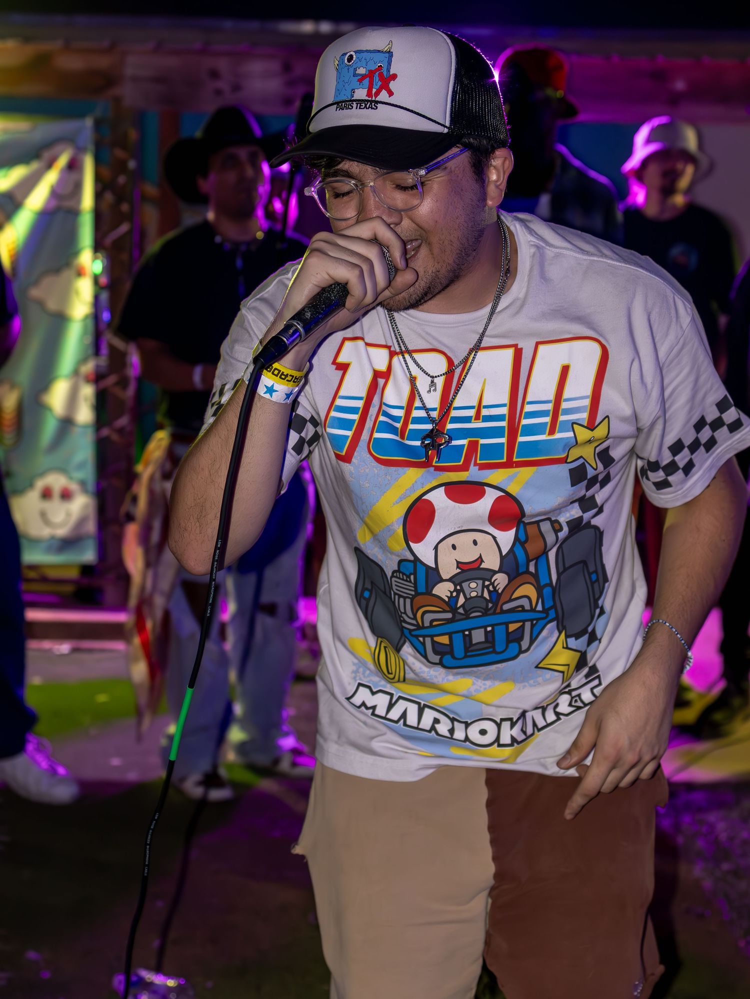 Close-up of Mario Kart themed t-shirt designs at performance with colorful stage lighting.