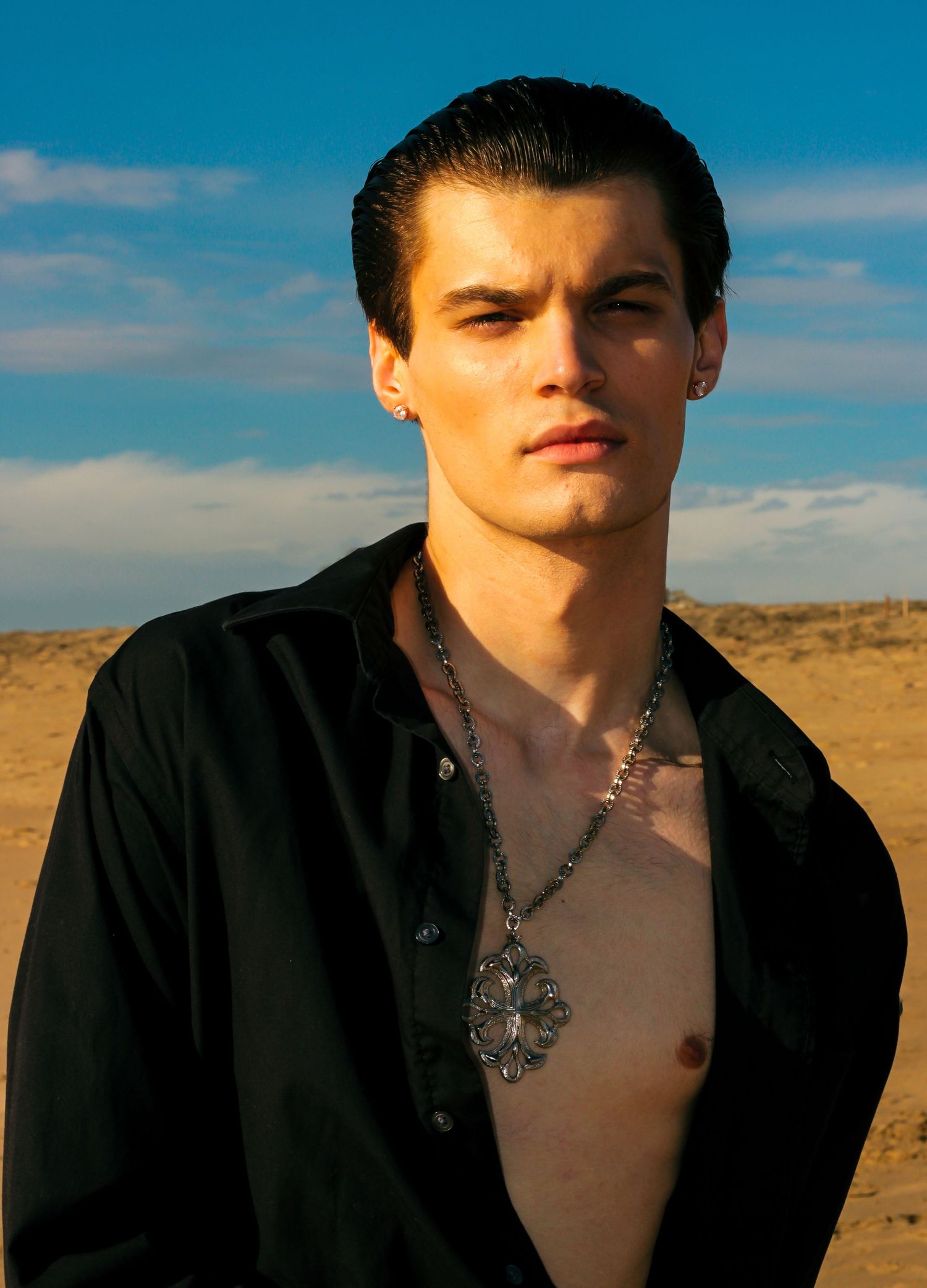 Artistic beach portrait against vibrant blue sky and desert landscape.