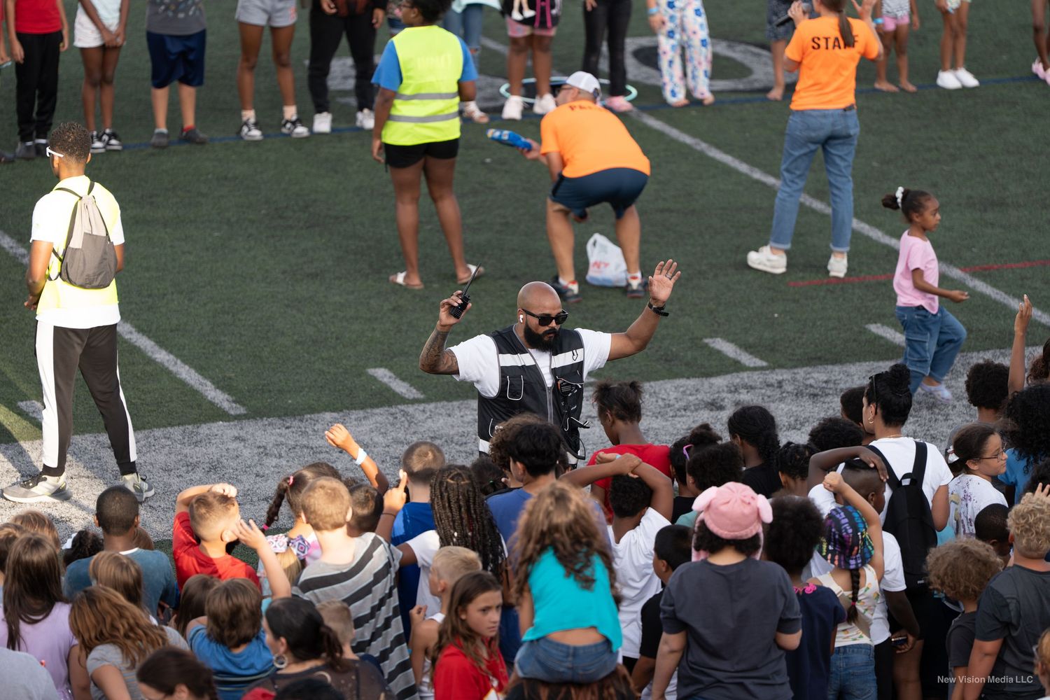Large crowd of spectators watching an event on a sports field from the stands.