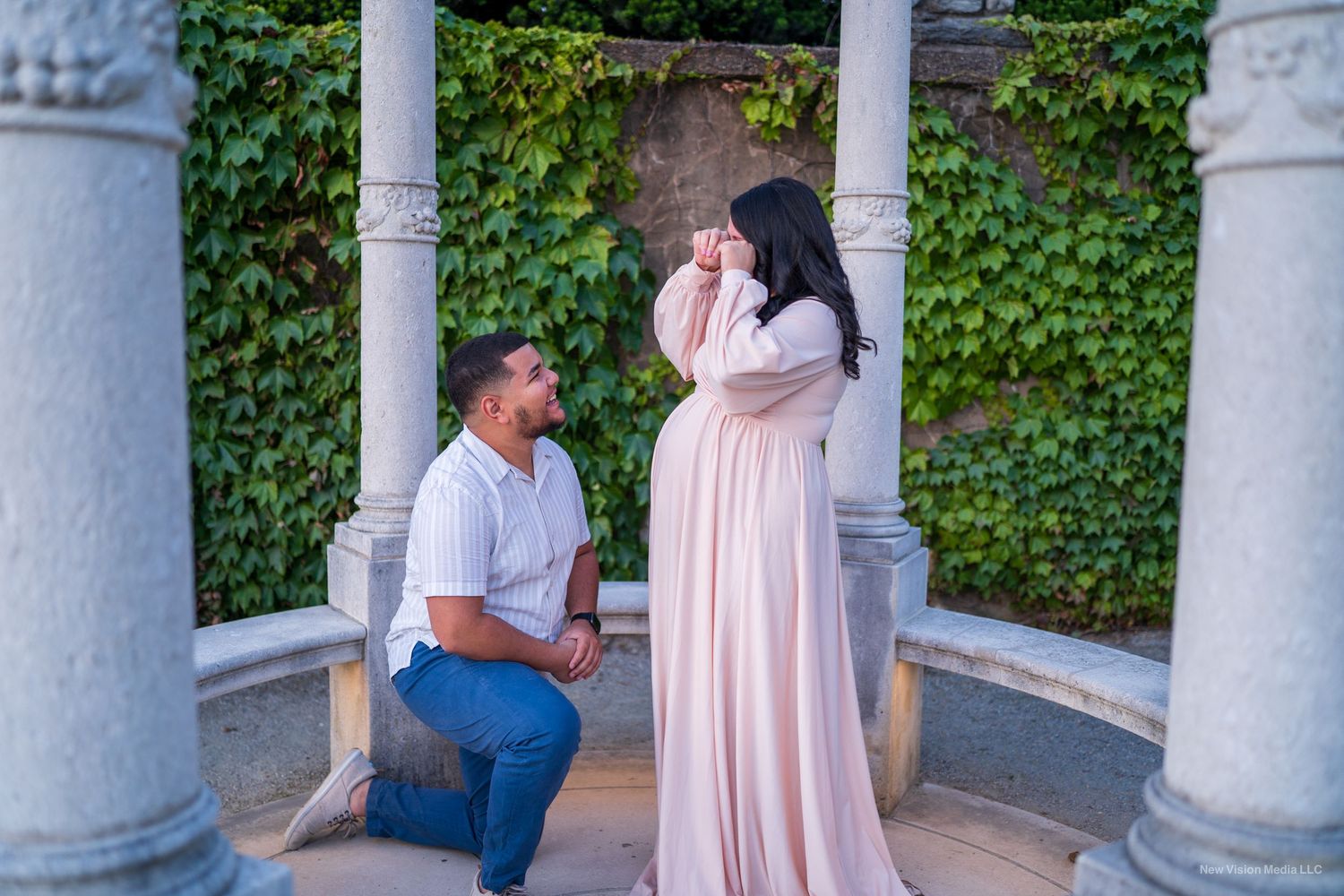 Proposal between white stone columns with ivy-covered walls.